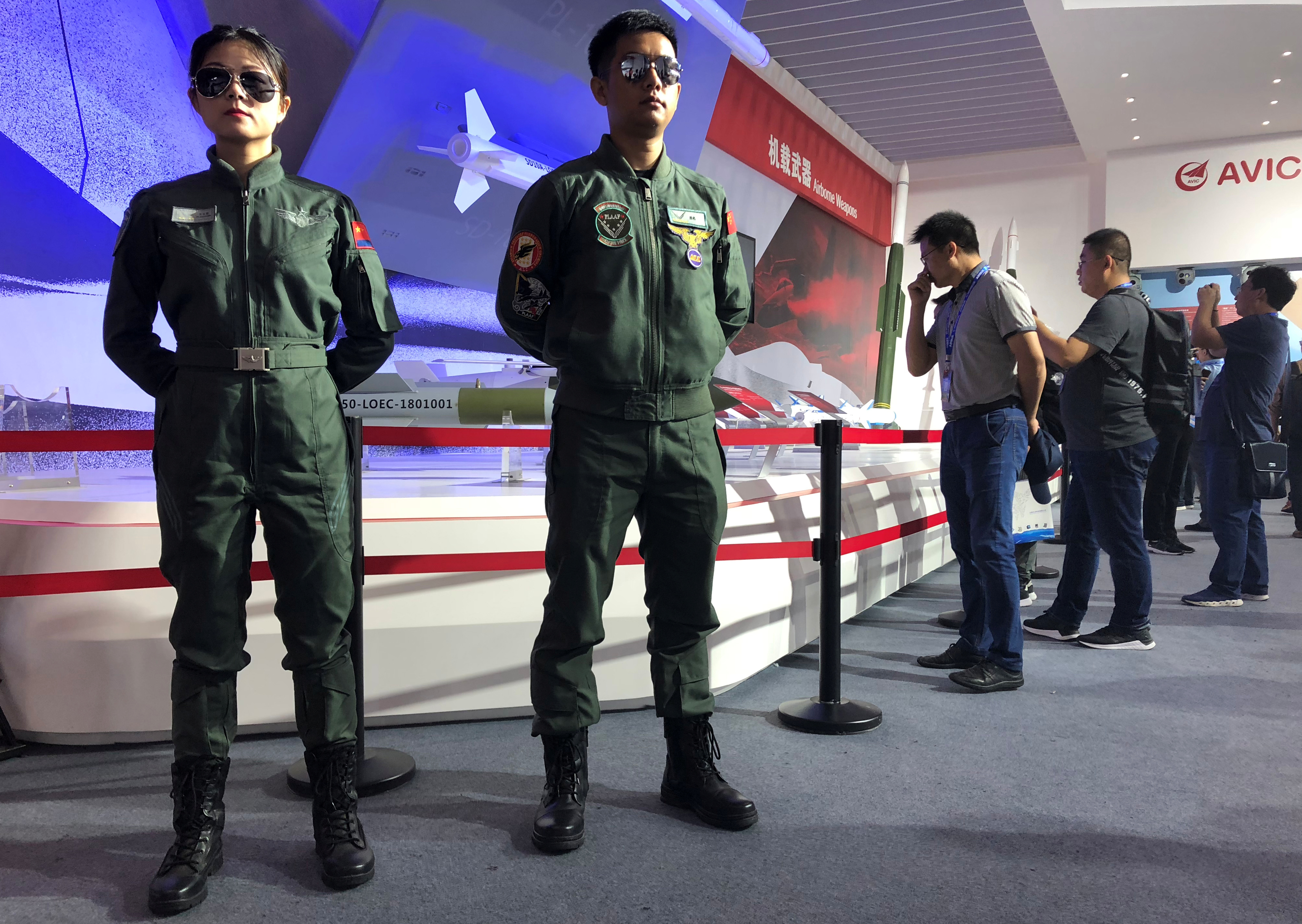 Visitors look at airborne weapons displayed at a booth of AVIC at the Zhuhai Airshow in Zhuhai
