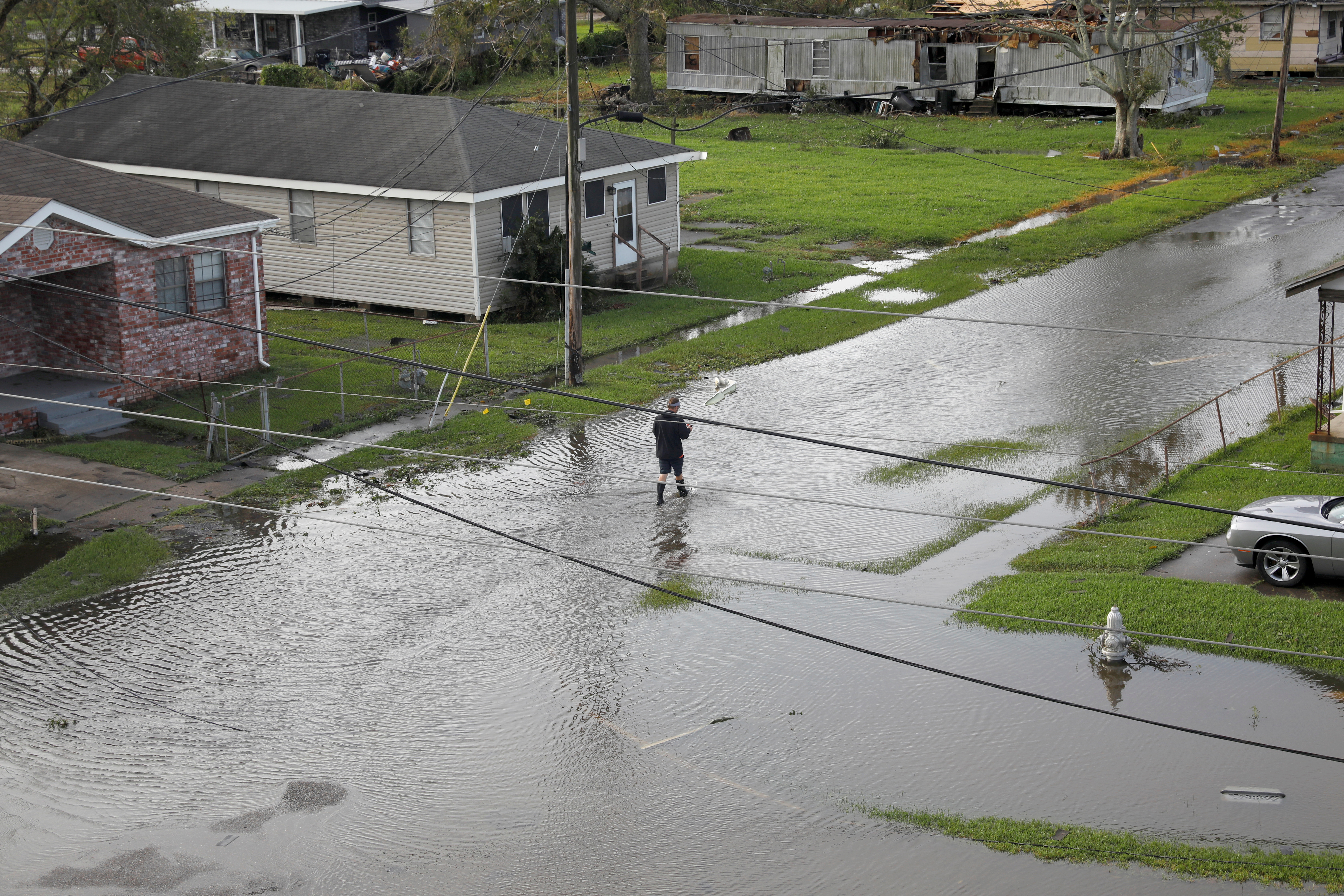 A person walks in a flooded street after Hurricane Ida made landfall in Louisiana, in Kenner, Louisiana, U.S. August 30, 2021. REUTERS/Marco Bello