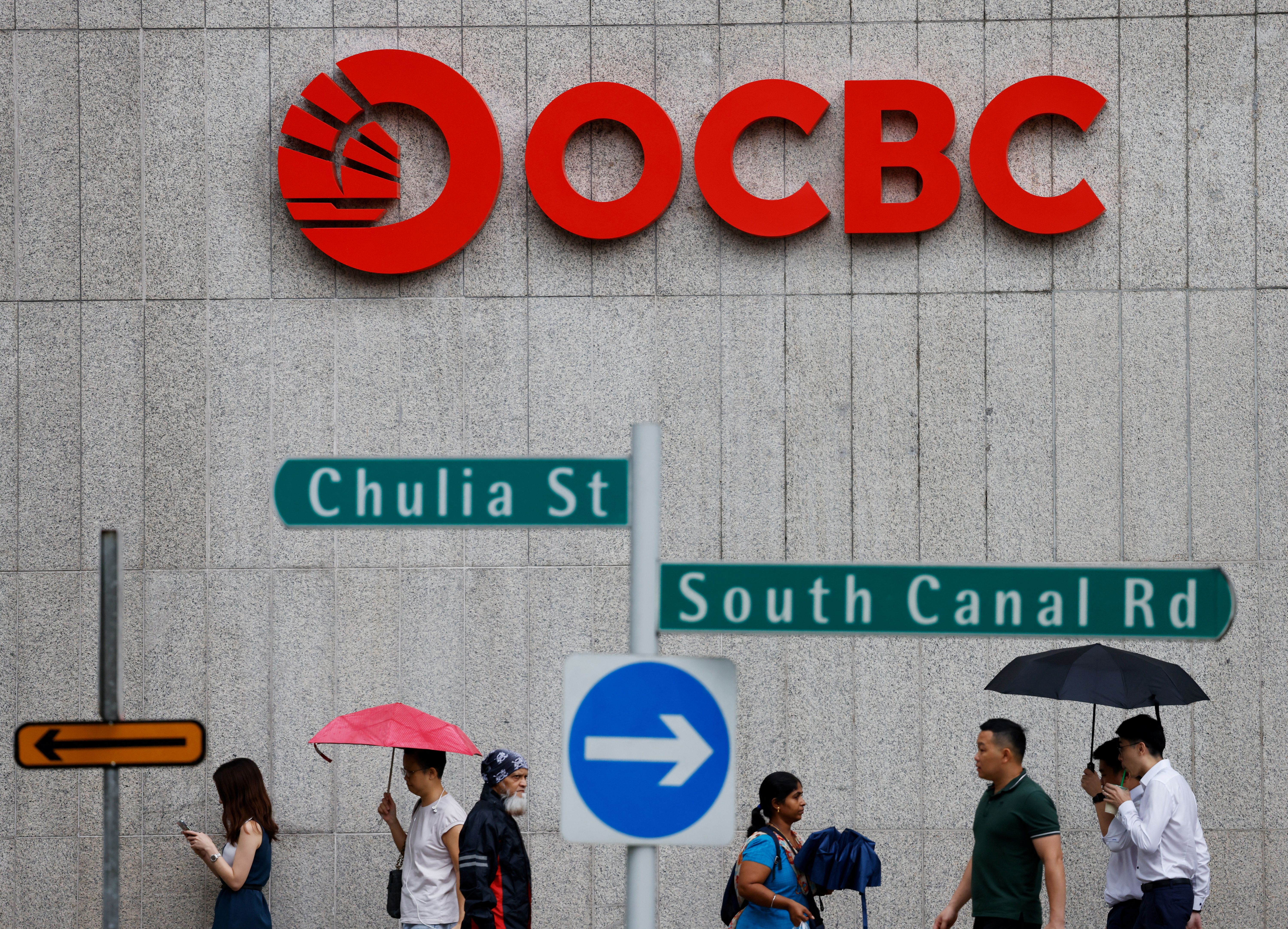 People pass an OCBC Bank signage in Singapore