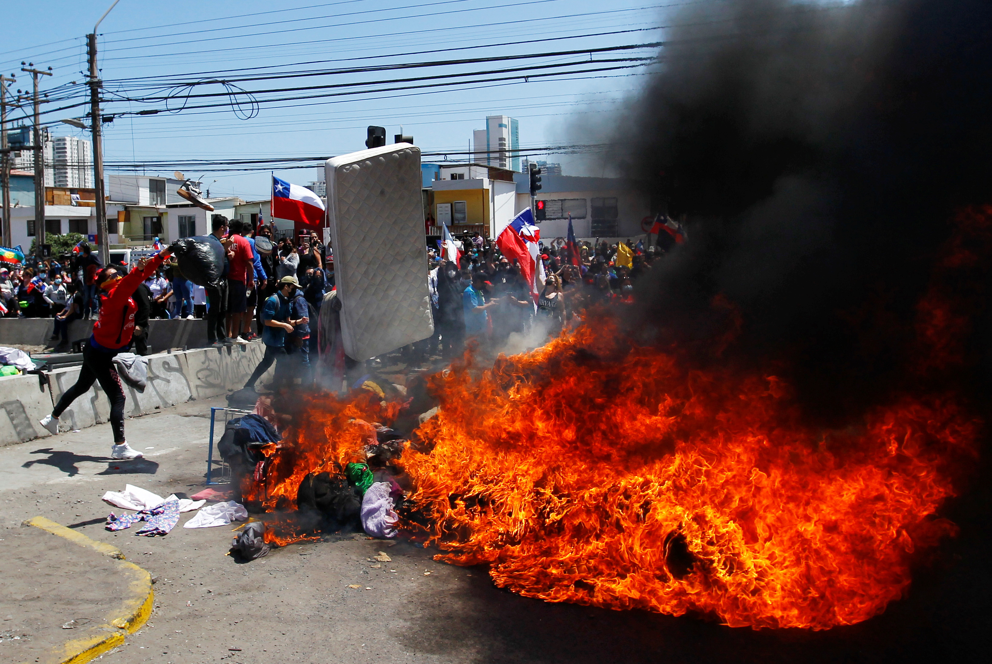 Demonstrators burn the belongings of Venezuelan migrants at a makeshift camp in a public square during a rally against the migration in Iquique, Chile, September 25, 2021. REUTERS/Alex Diaz 