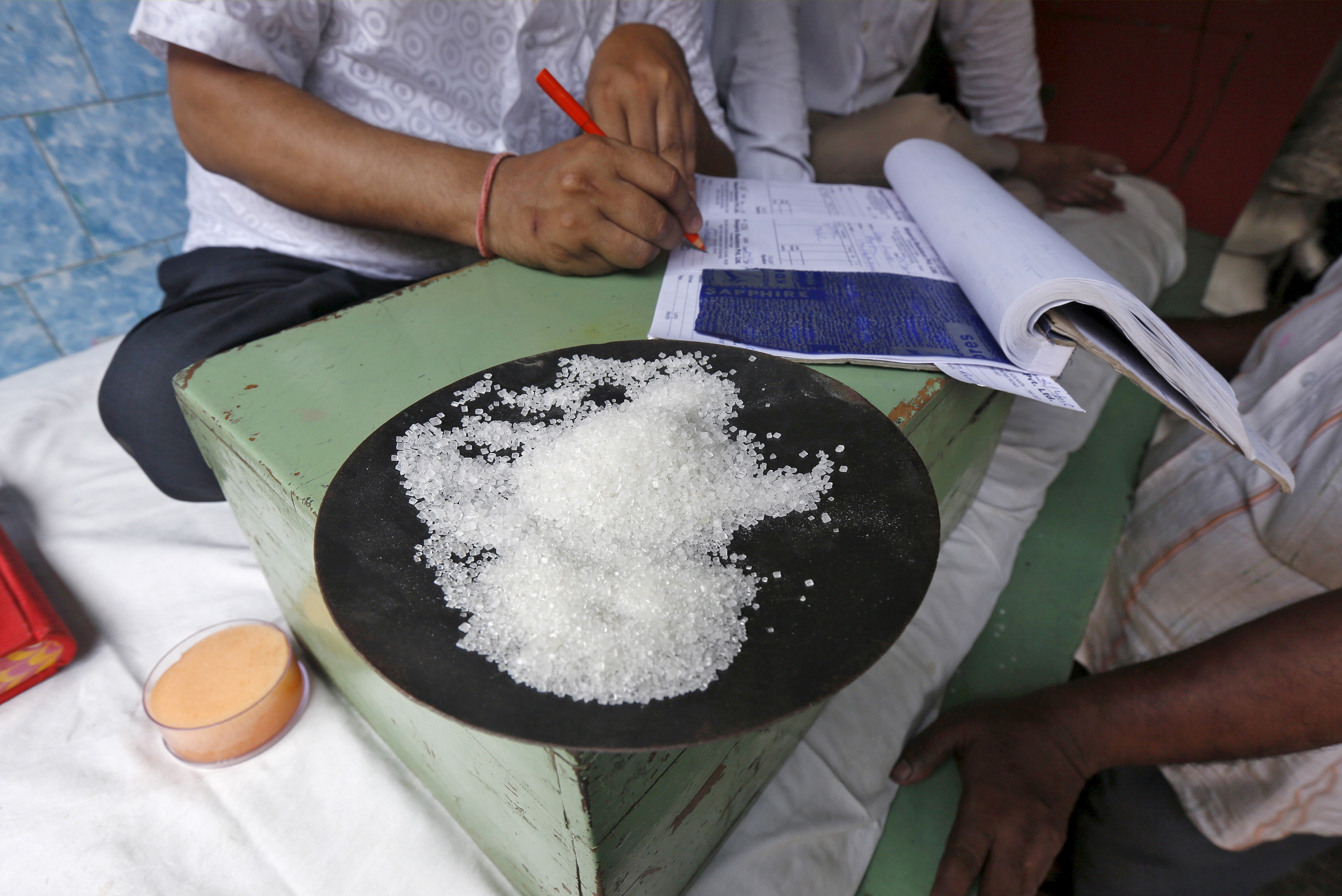 Una muestra de cristales de azúcar se ve en el escritorio de un comerciante en un mercado mayorista en Calcuta.