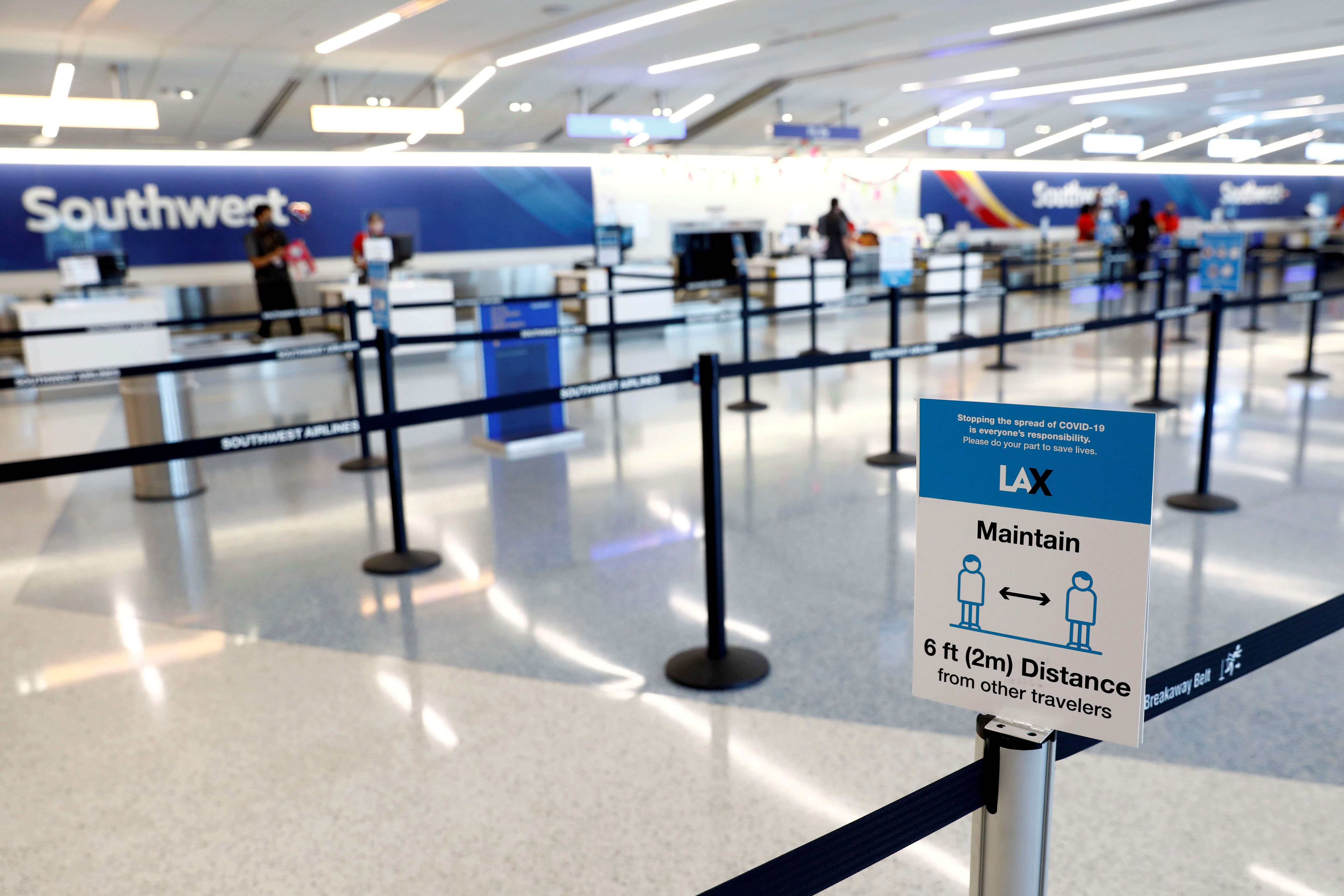 A social distancing sign is displayed at a check-in area for Southwest Airlines Co. at Los Angeles International Airport during the outbreak of the coronavirus disease in Los Angeles, California, U.S., May 23, 2020. REUTERS/Patrick T. Fallon