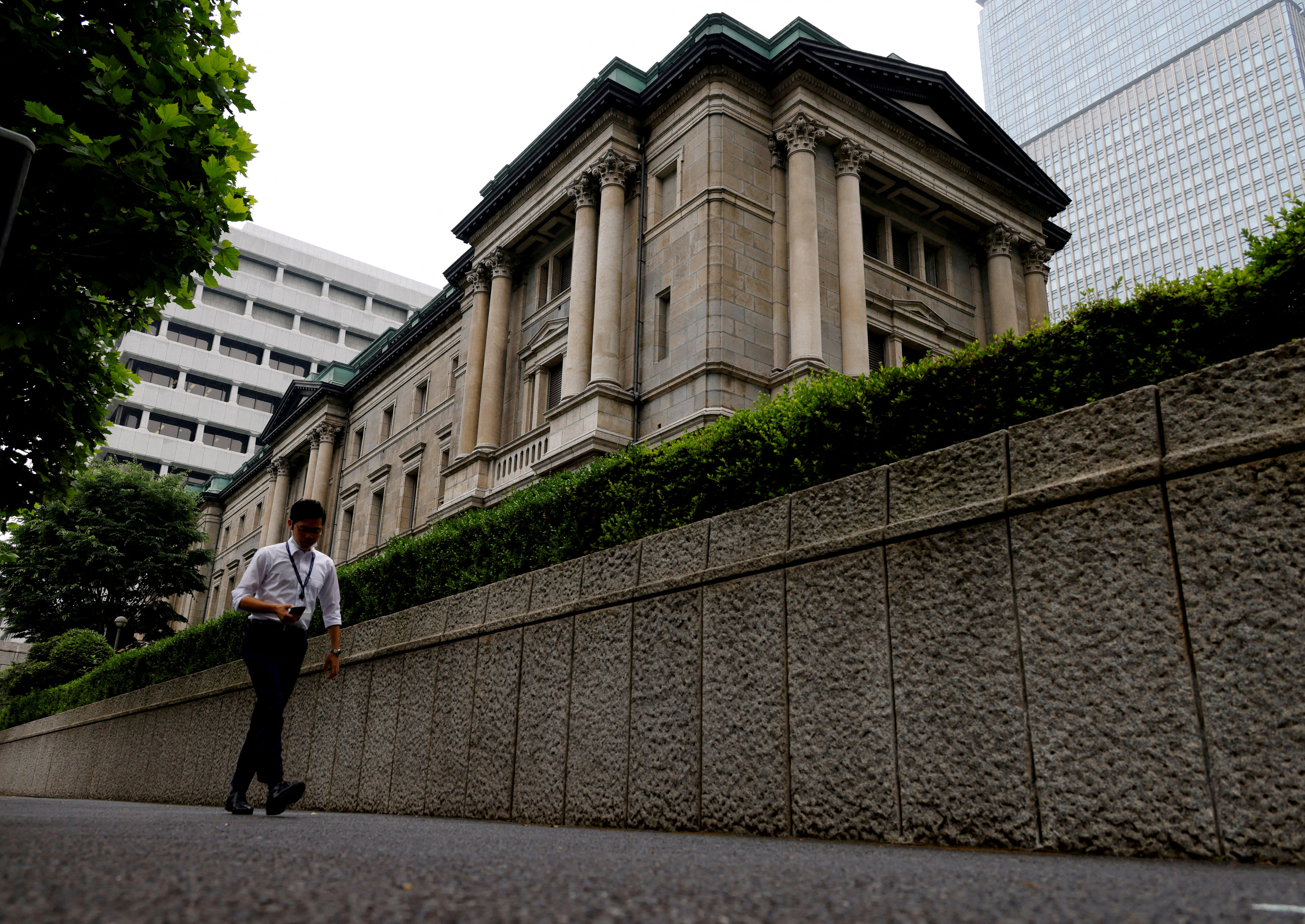 FILE PHOTO: A man walks past Bank of Japan's headquarters in Tokyo