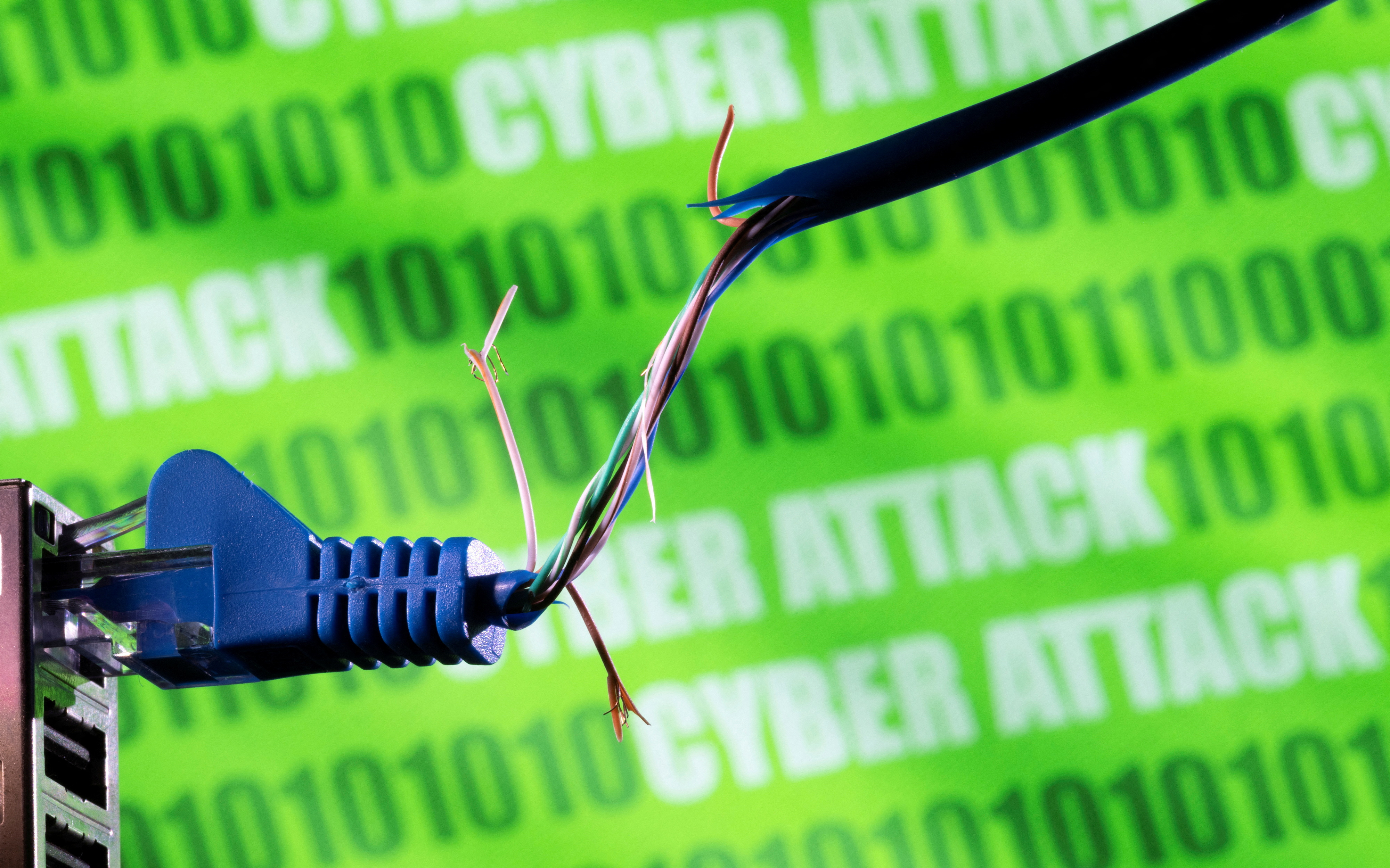 Illustration shows broken Ethernet cable, binary code and words "cyber attack\