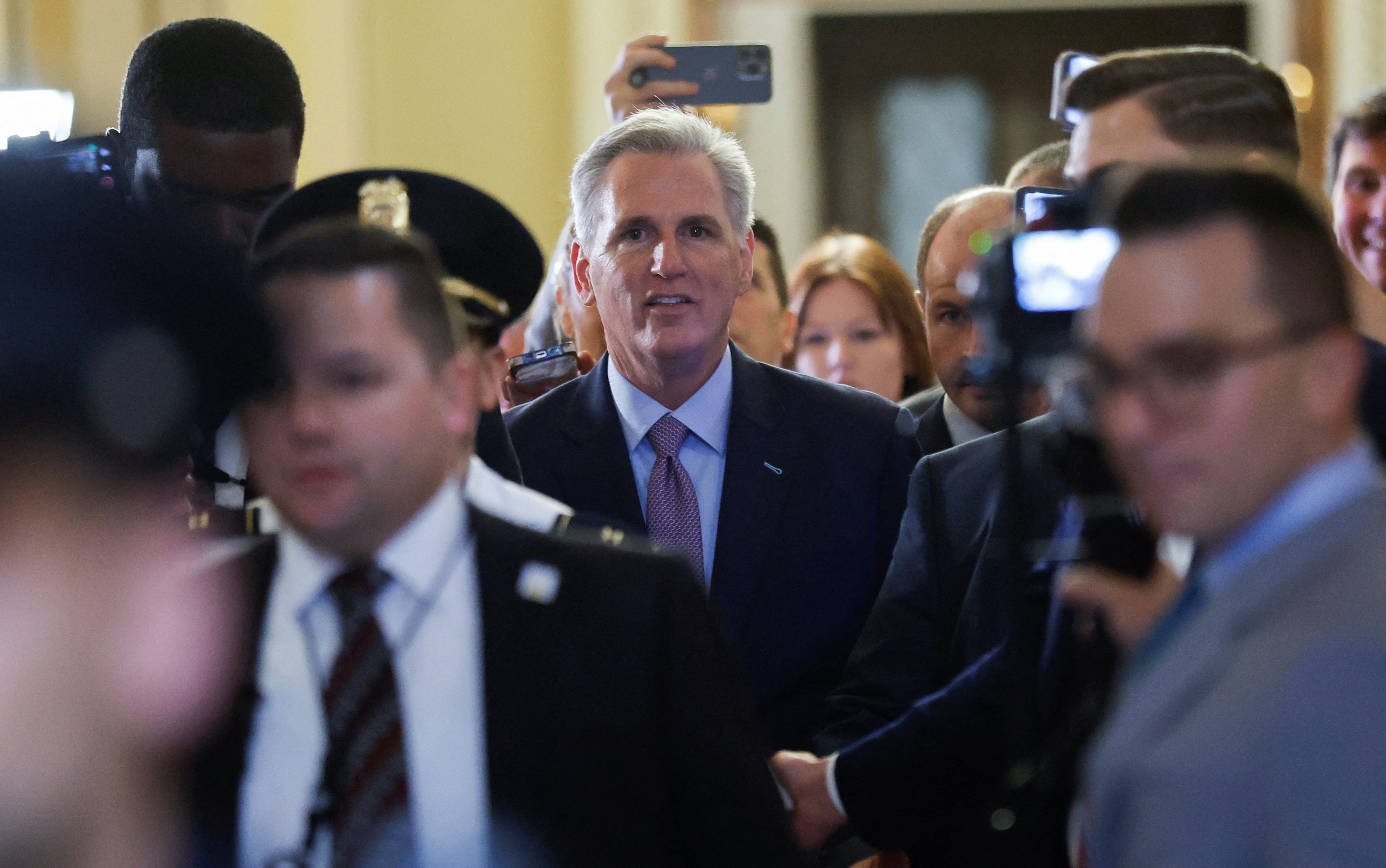U.S. House Speaker Kevin McCarthy walks through crowd of reporters at Capitol in Washington