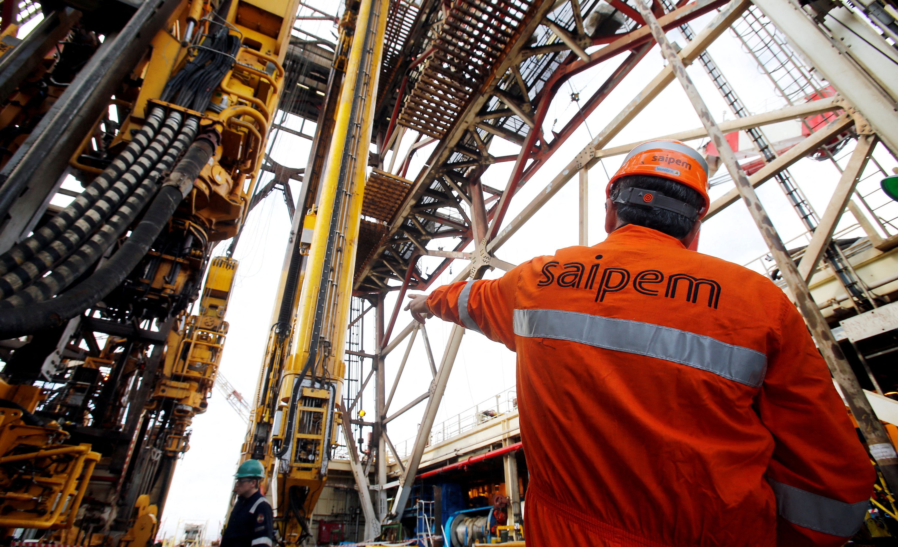 A staff member gestures on the Saipem 10000 deepwater drillship in Genoa's harbour