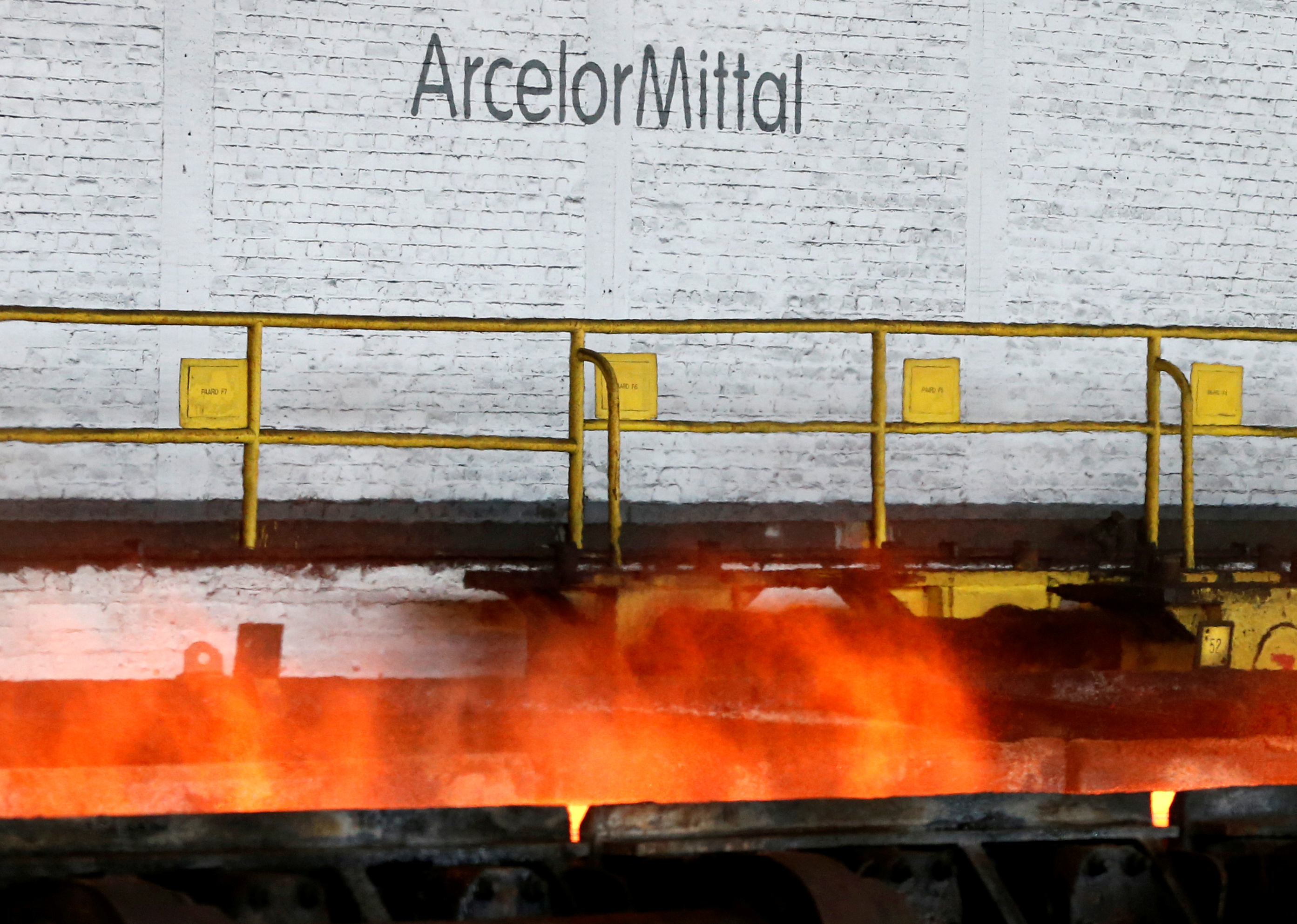 The logo of ArcelorMittal is pictured in front of heat rising from a red-hot steel plate at the ArcelorMittal steel plant in Ghent