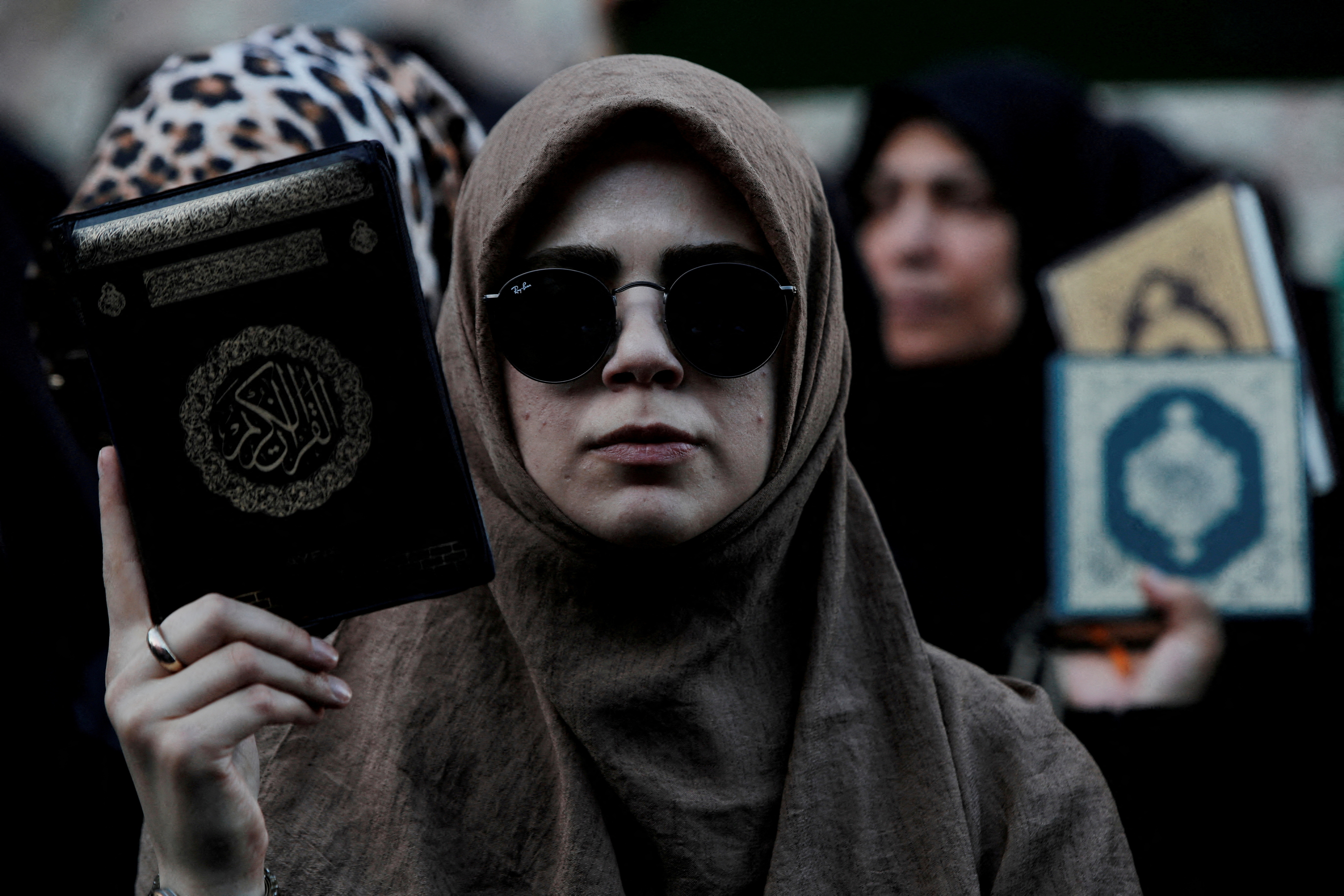 FILE PHOTO: Protesters hold copies of the Koran as they demonstrate outside the Consulate General of Sweden in Istanbul