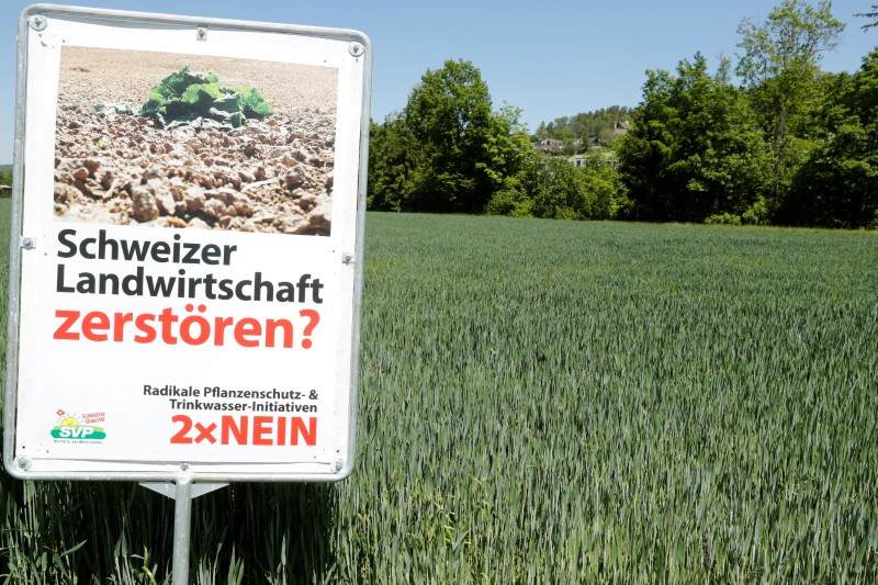 A poster is placed in front of a field near Aesch