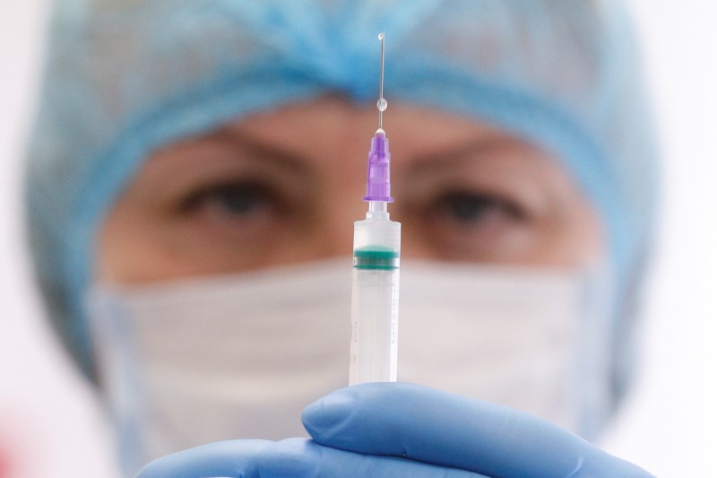 A medical worker shows a syringe with the CoronaVac vaccine in Kyiv