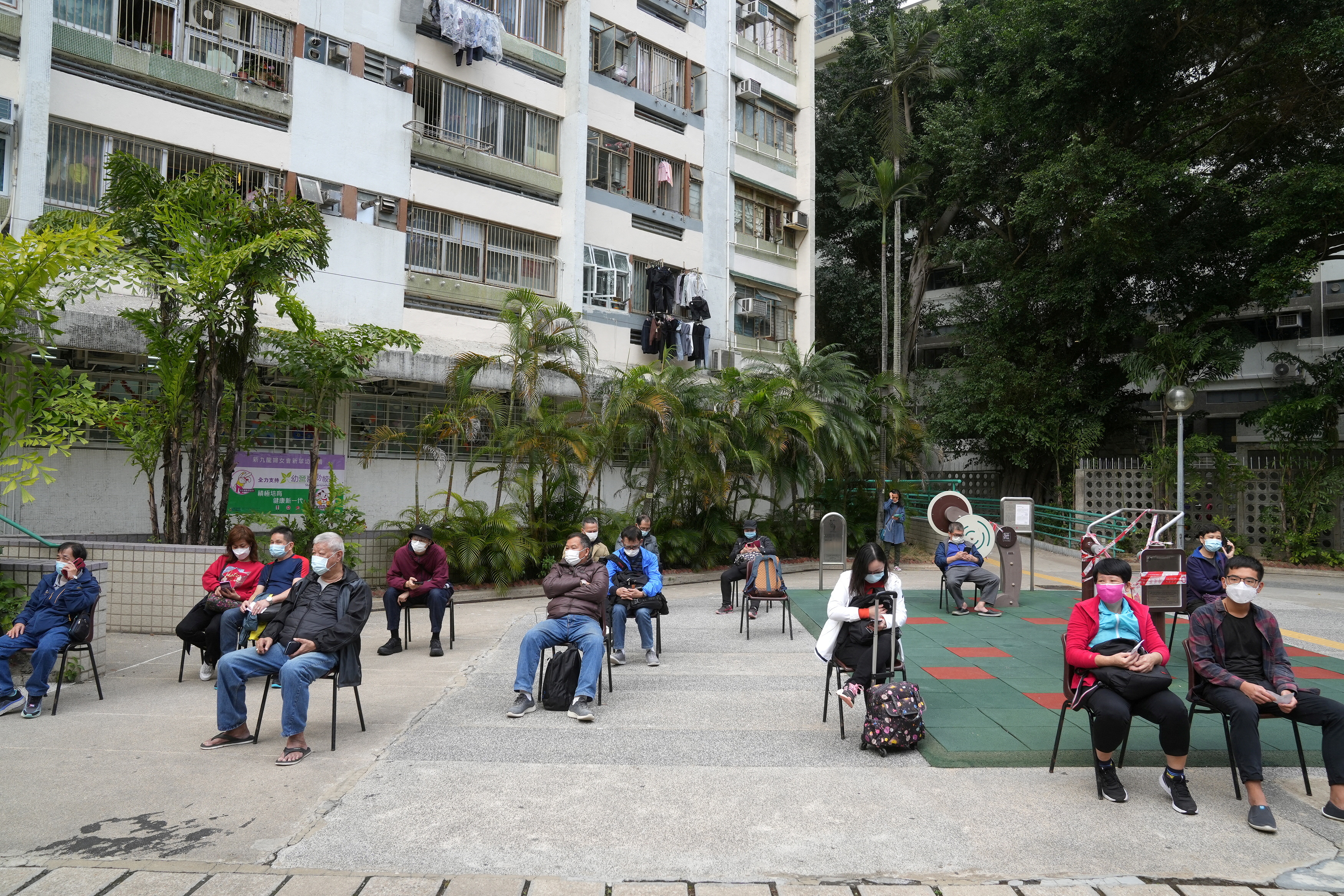 People wait for their swab samples to be collected at a makeshift testing site for the coronavirus disease (COVID-19), in Hong Kong