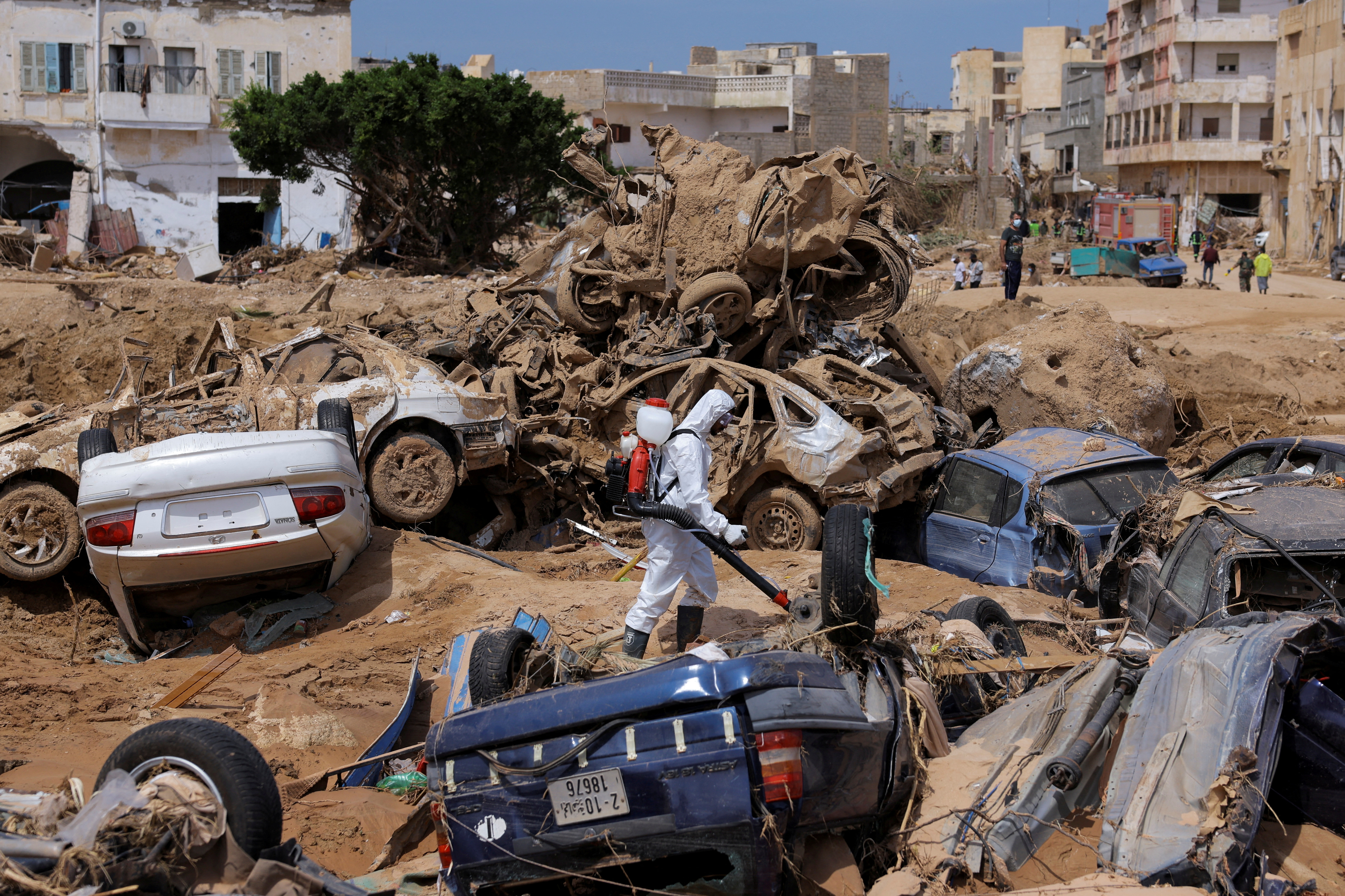 Sanitation worker disinfects rubble in Derna