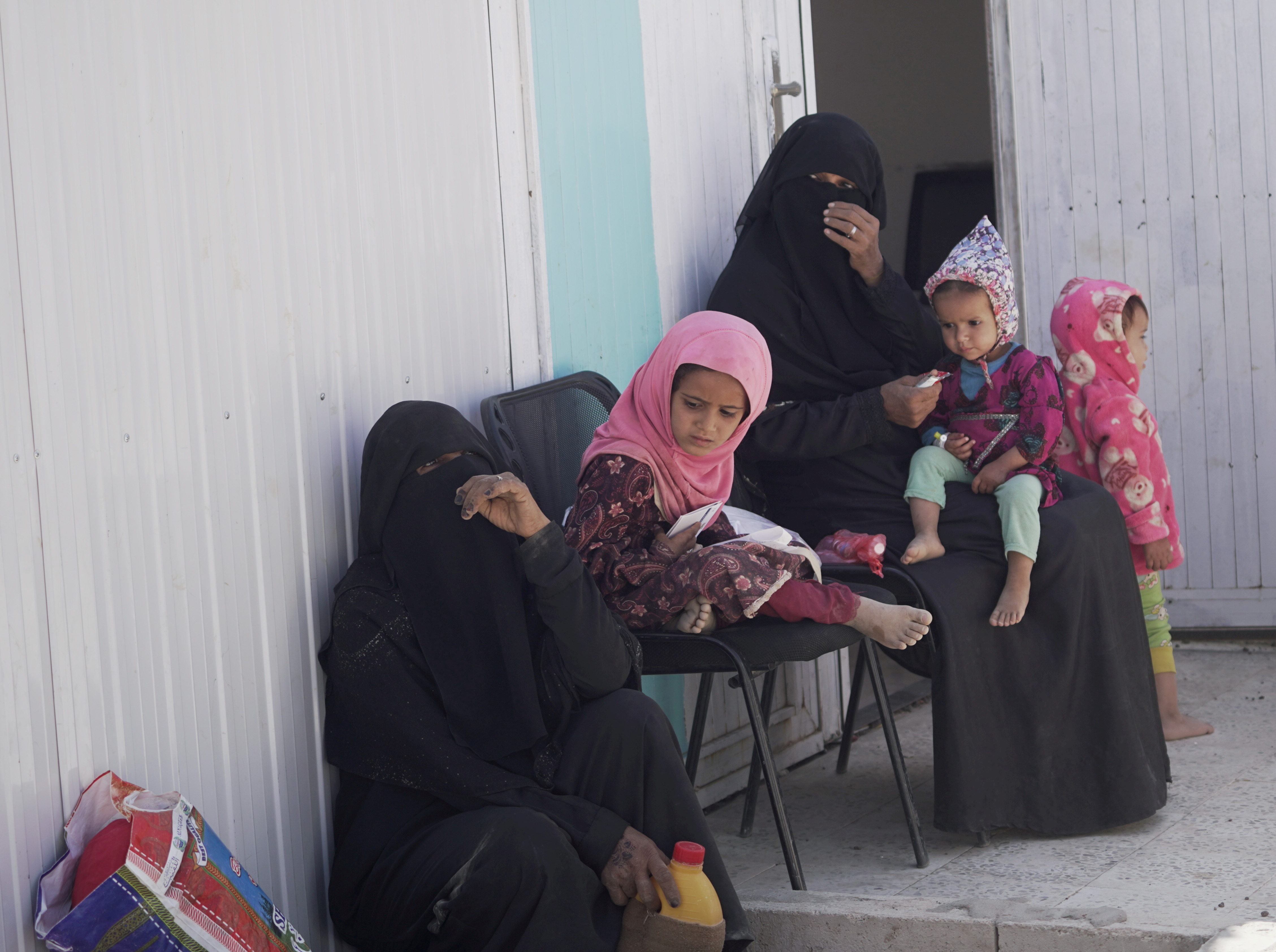 Women and children wait outside a clinic at a camp for internally displaced people (IDPs) in Marib, Yemen, November 3, 2021. REUTERS/Nabeel al-Awzari/File Photo