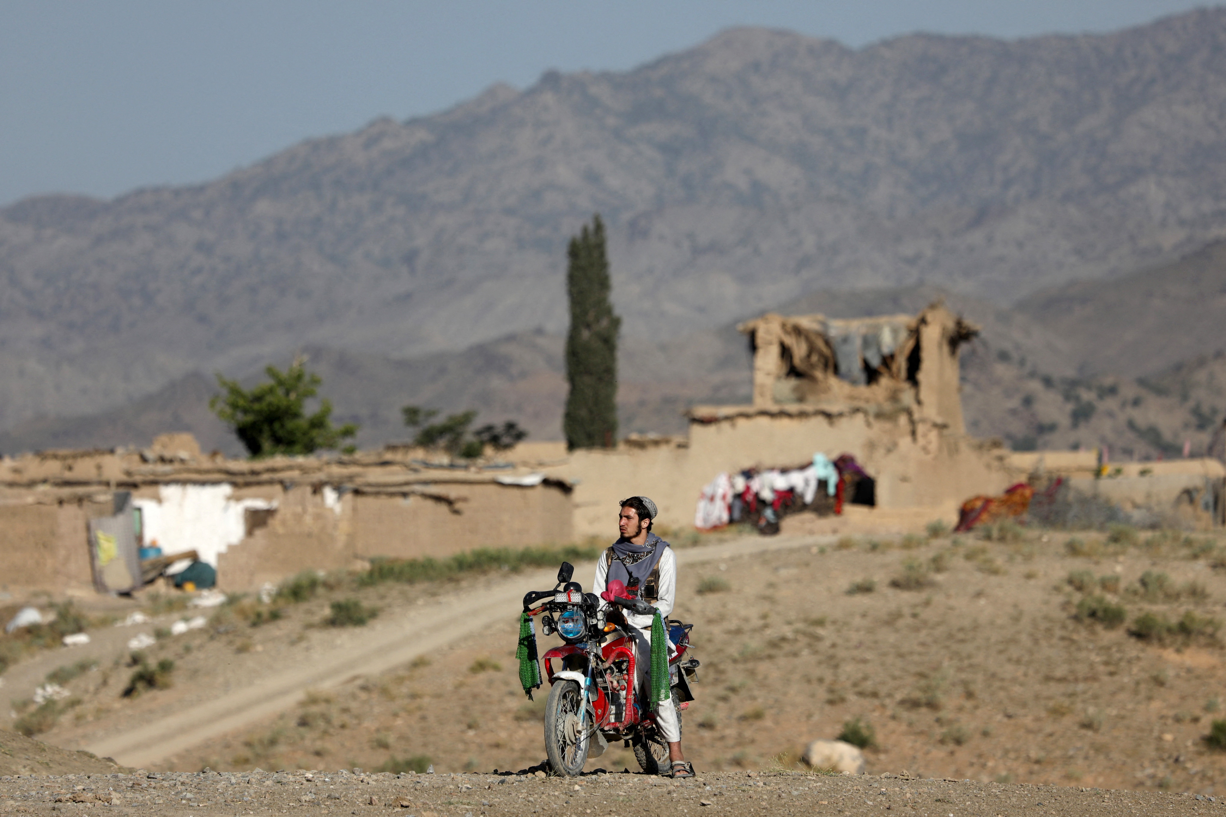 An Afghan man sits on a motorbike in the quake-hit area of Wor Kali village