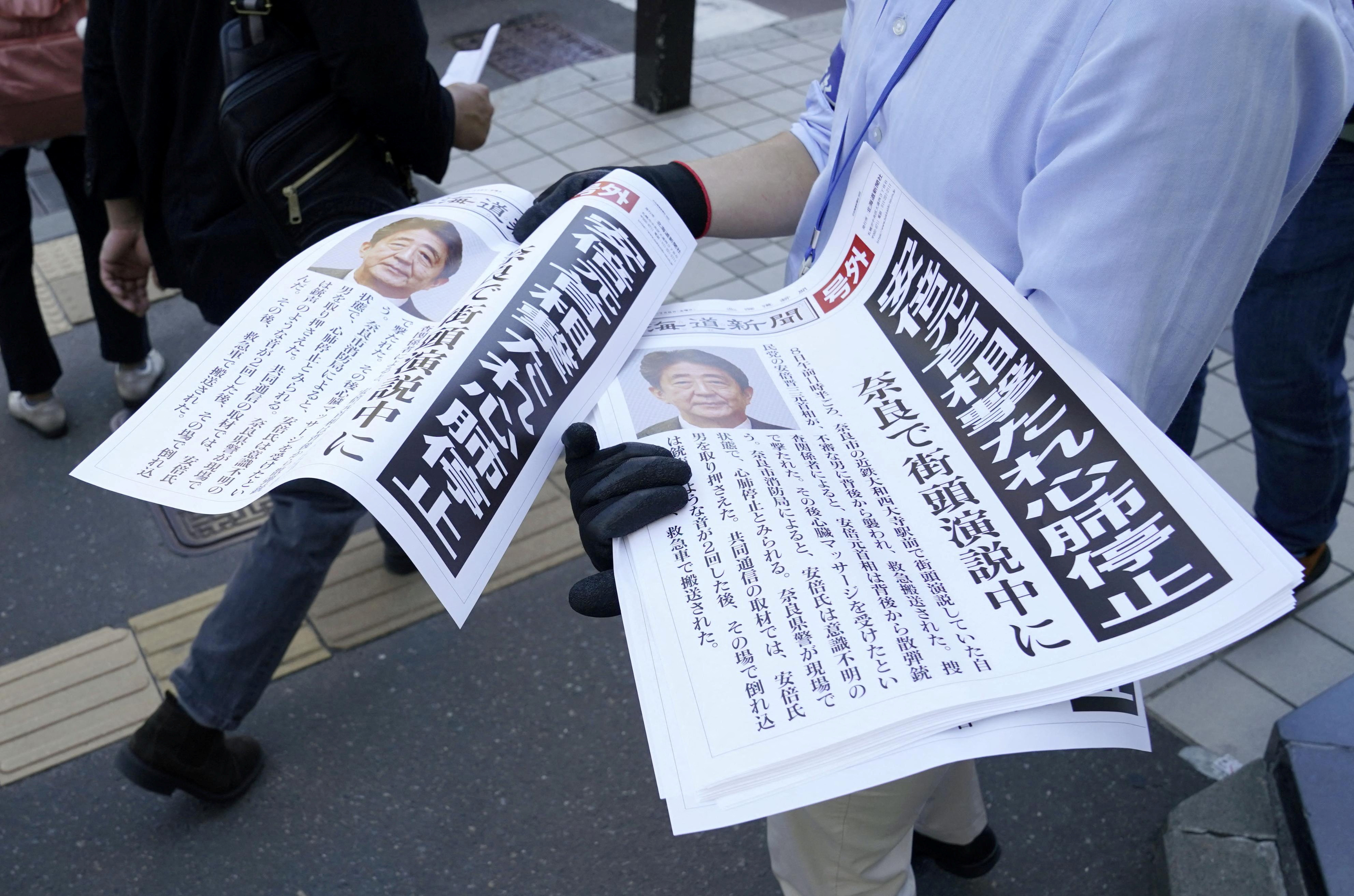 Copies of an extra edition of a newspaper is handed out to pedestrians in Sapporo, after former Japanese Prime Minister Shinzo Abe was shot, in Sapporo