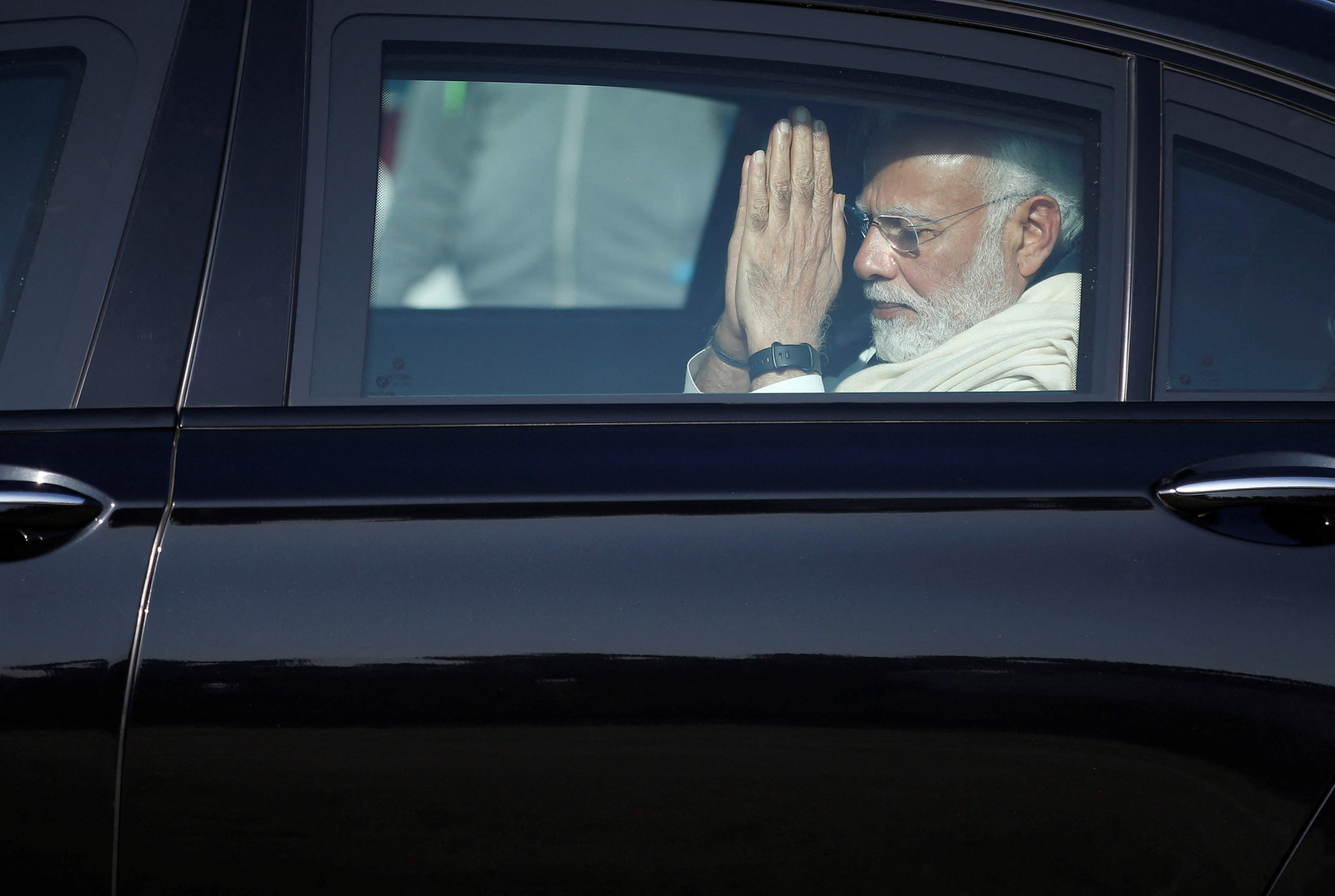 Indian Prime Minister Narendra Modi gestures as he leaves in a car after attending the funeral of his mother Heeraben, in Gandhinagar