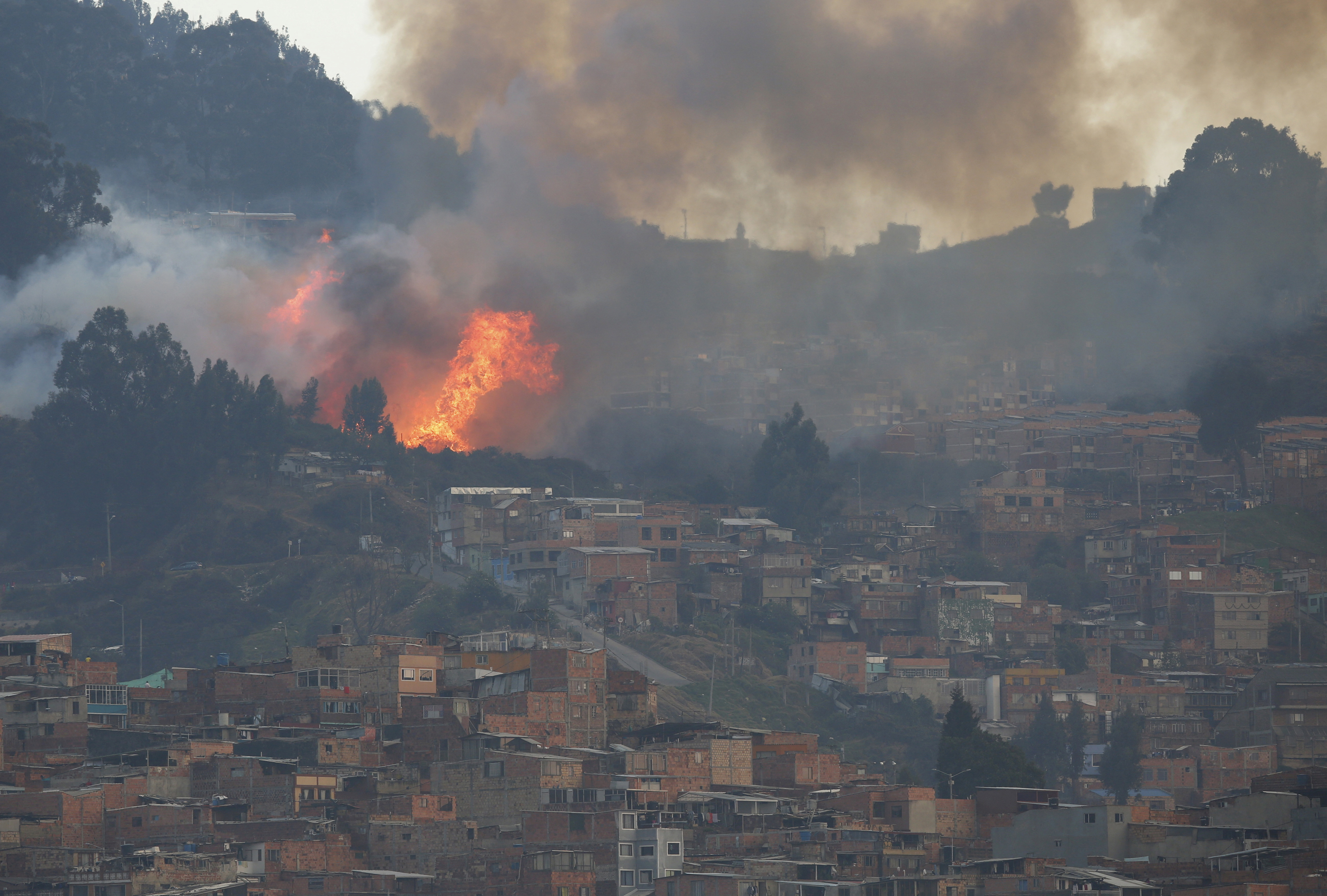 Smoke rises from a forest fire on a hill area, near neighborhoods on the south side of Bogota, Colombia.