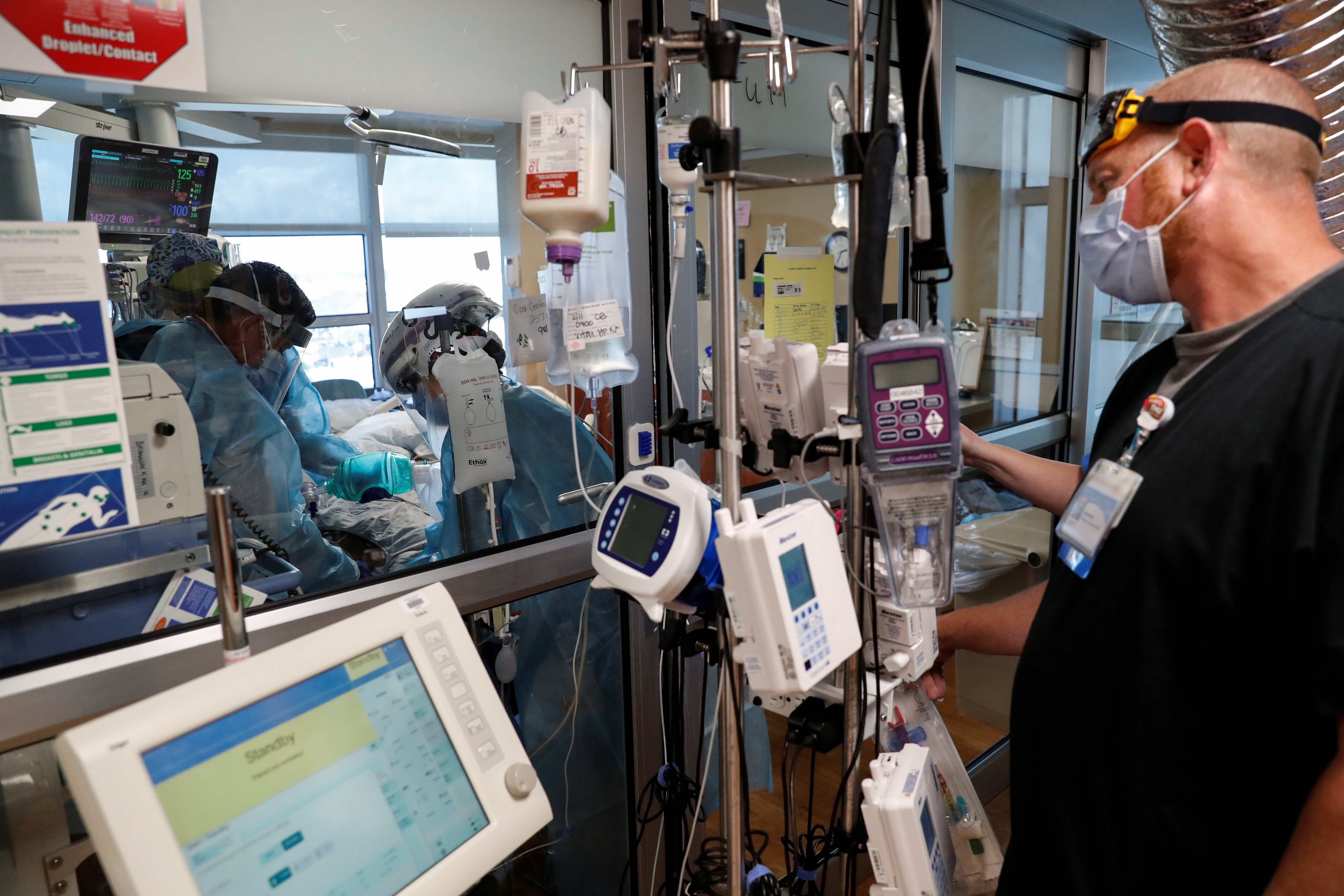Critical care workers insert an endotracheal tube into a coronavirus disease (COVID-19) positive patient in the intensive care unit (ICU) at Sarasota Memorial Hospital in Sarasota, Florida, February 11, 2021. REUTERS/Shannon Stapleton