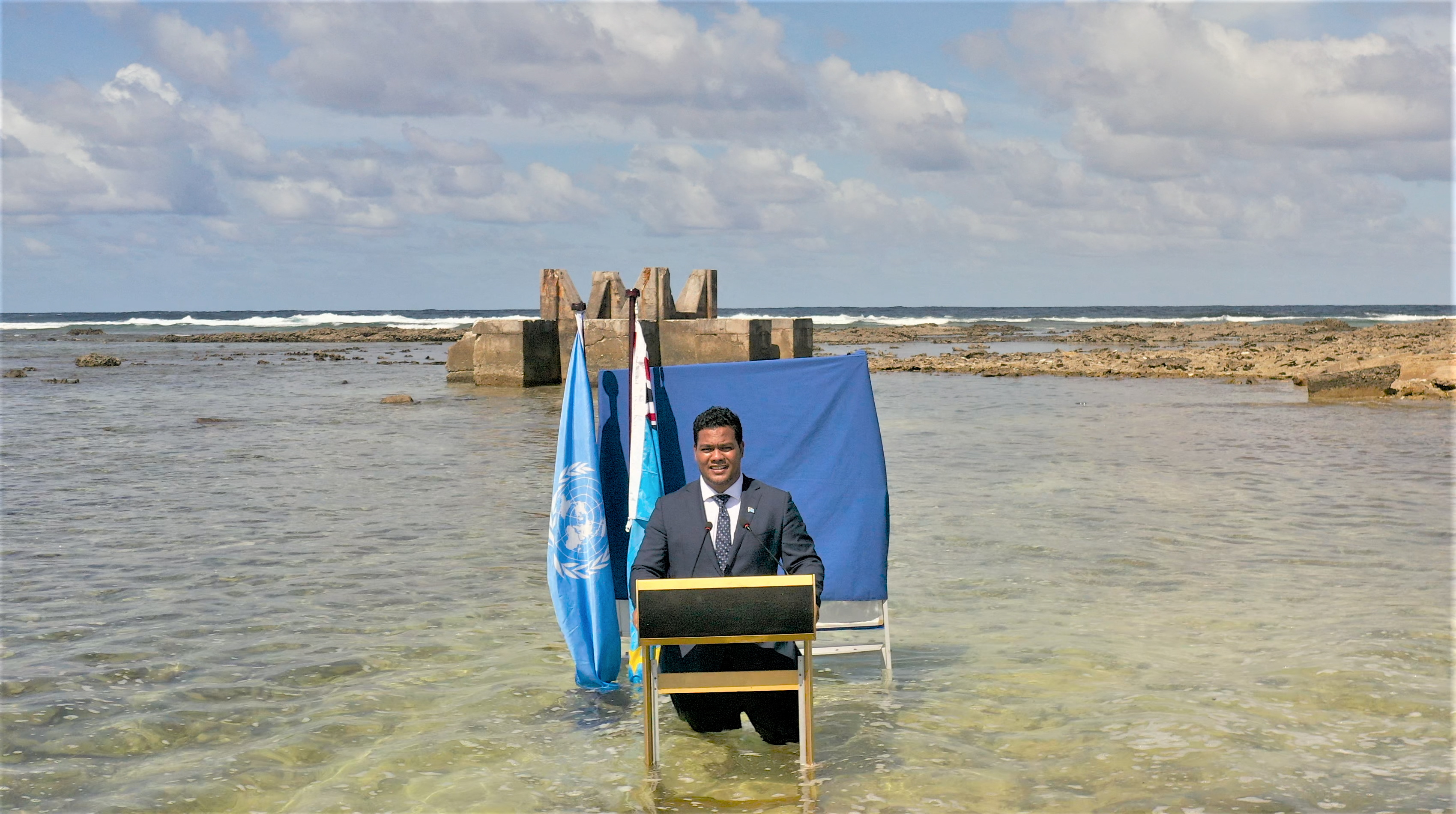 Tuvalu's Foreign Minister Simon Kofe gives a COP26 statement while standing in the ocean, in Funafuti