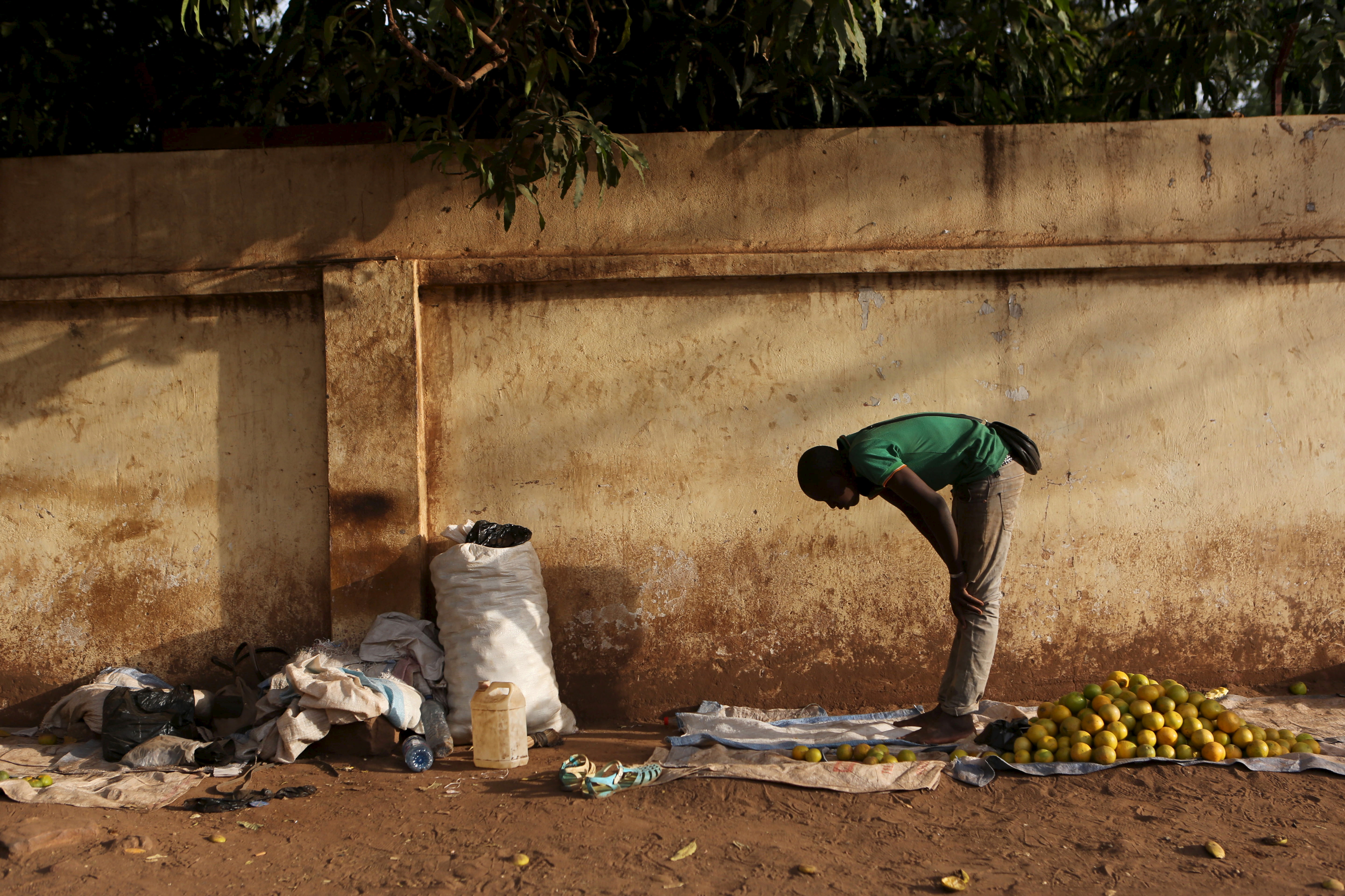 A fruit vendor prays on the side of a street in Bamako