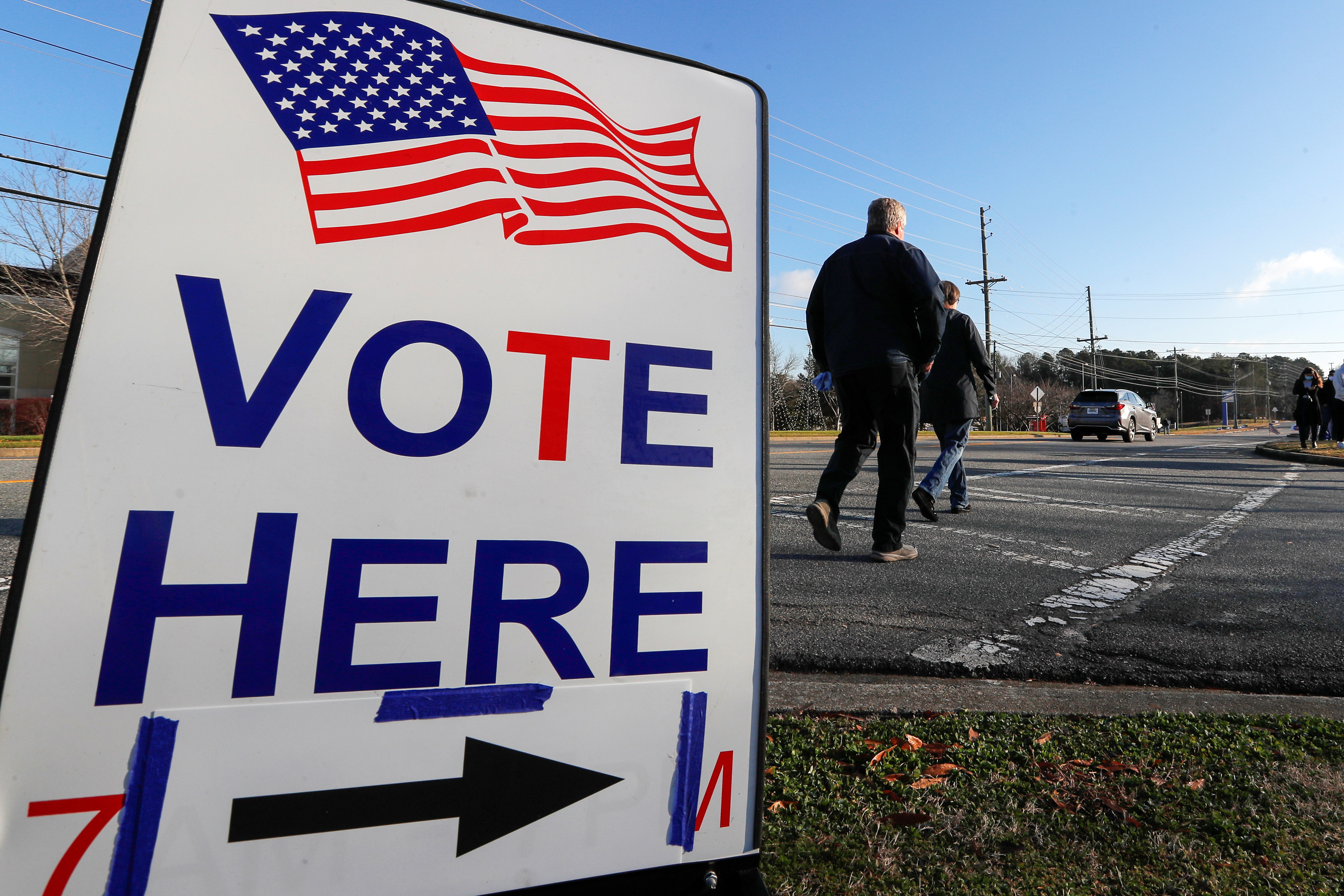 A sign is seen as voters line up for the U.S. Senate run-off election, at a polling location in Marietta, Georgia, U.S., January 5, 2021. REUTERS/Mike Segar/File Photo