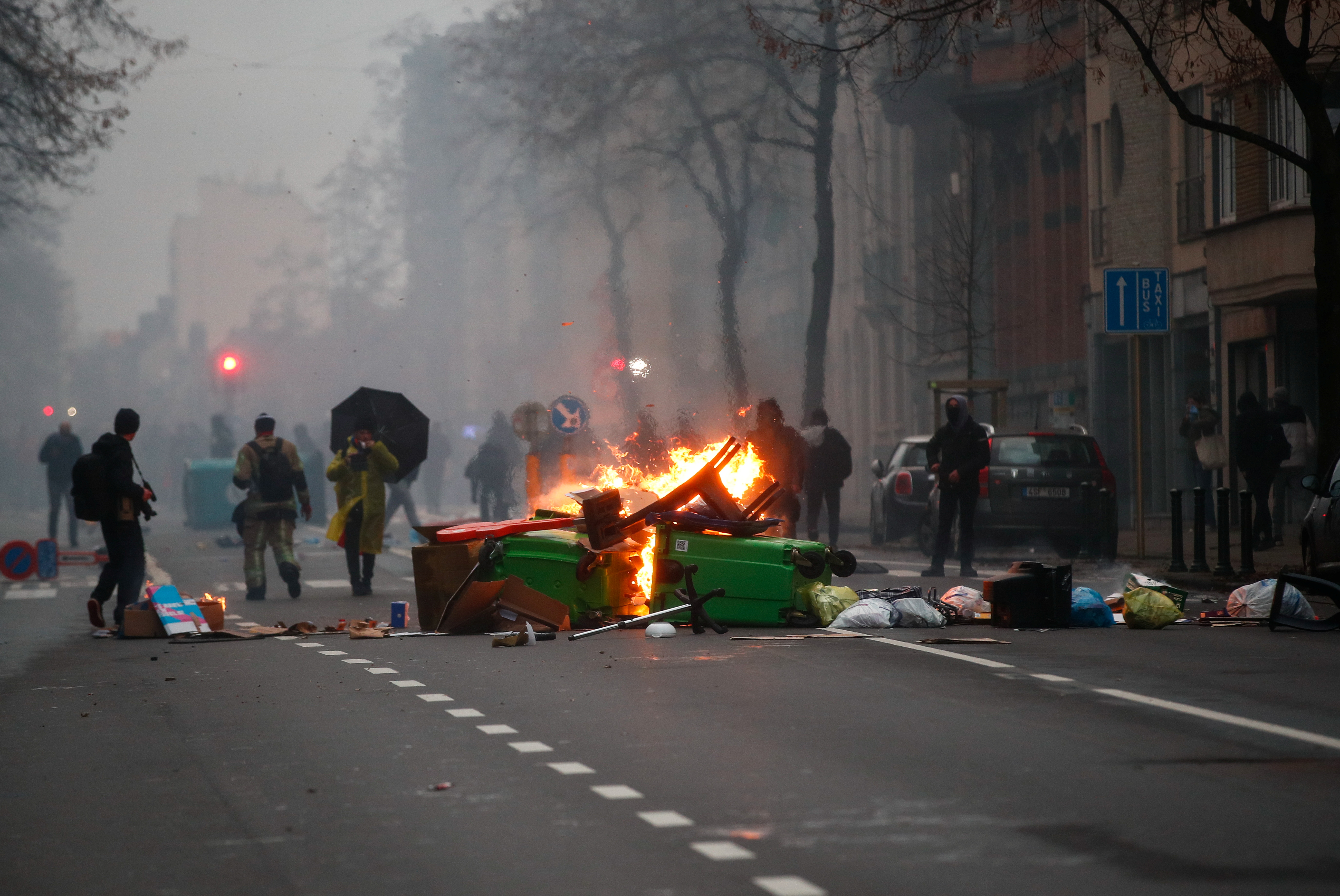 Burning objects are seen on the street during a protest against the Belgian government's restrictions imposed to contain the spread of the coronavirus disease (COVID-19), in Brussels, Belgium December 5, 2021. REUTERS/Johanna Geron