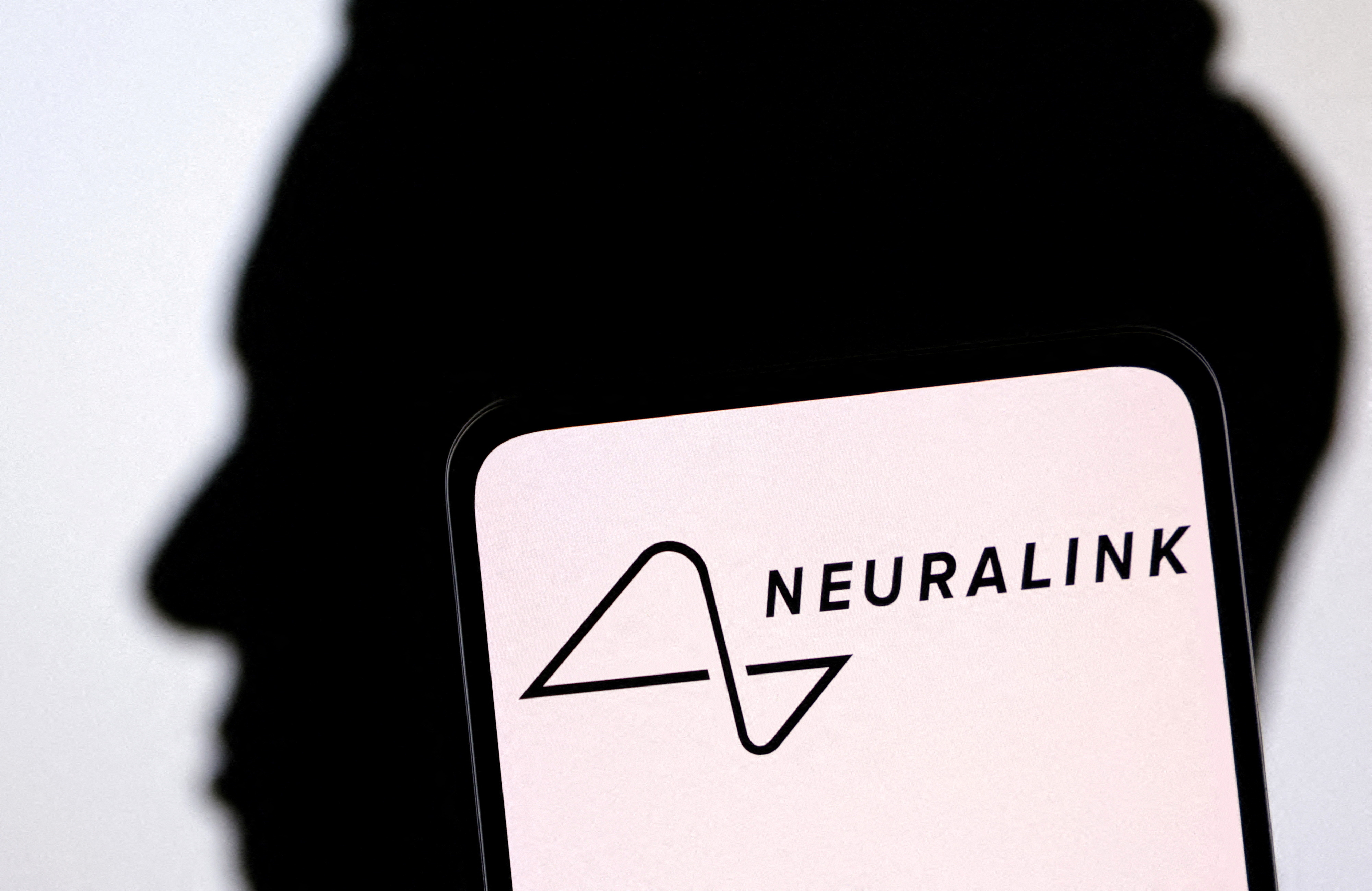 Illustration shows Neuralink logo and Elon Musk silhouette