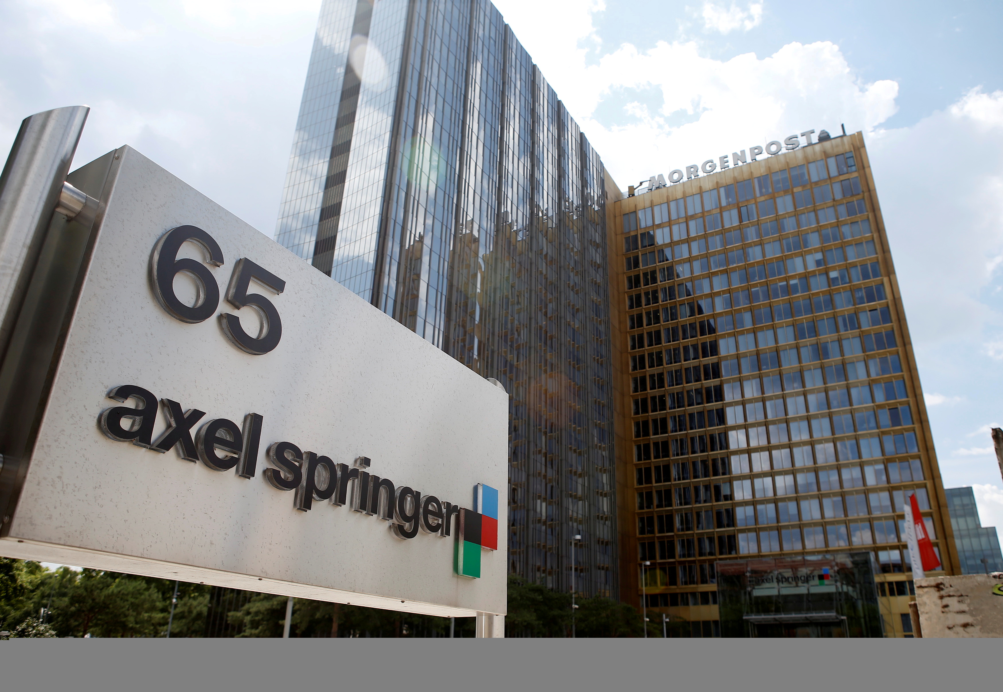 The logo of German publisher Axel Springer is pictured in front of the company's headquarters in Berlin