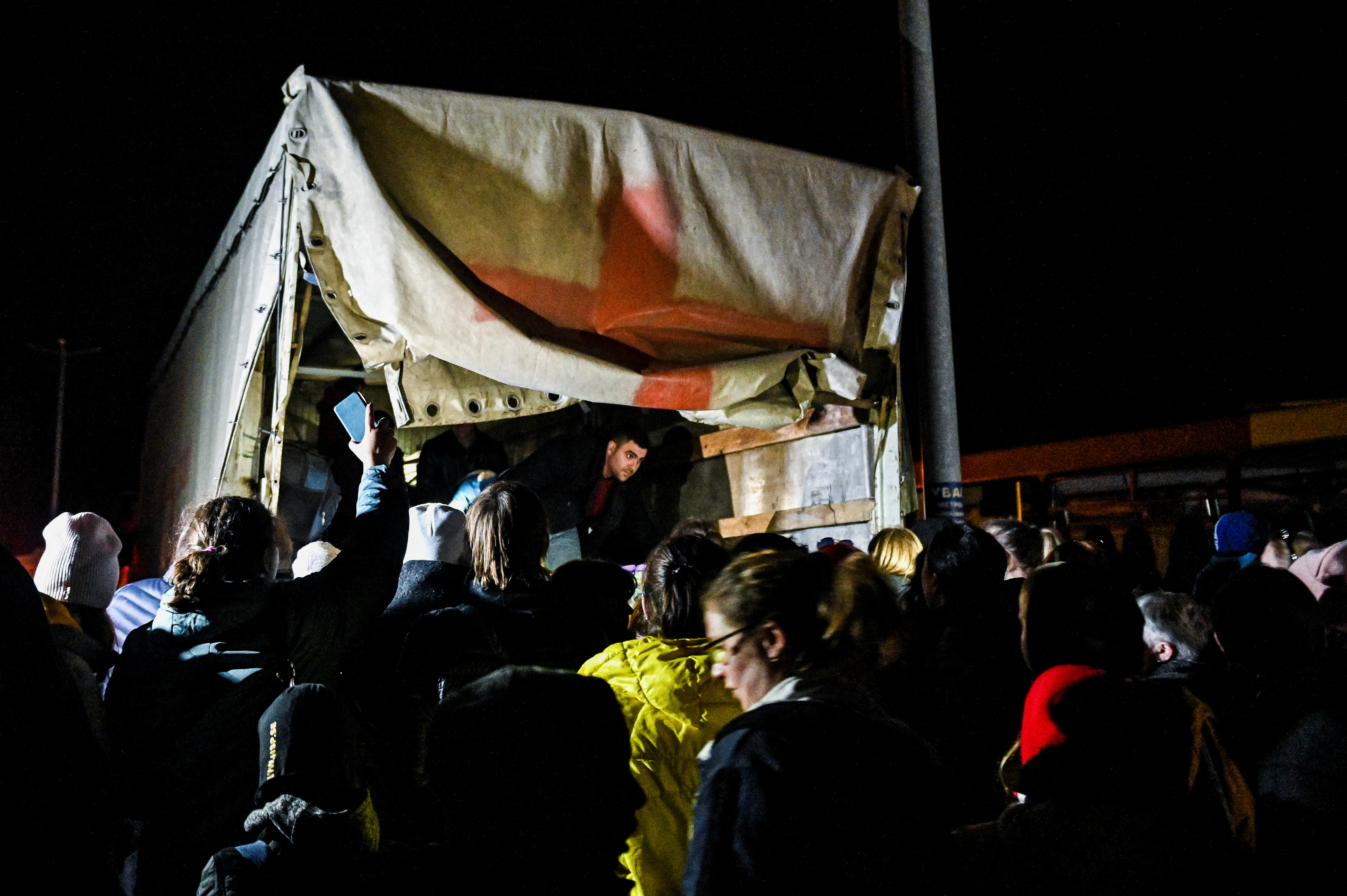 People who flee Mariupol and Melitopol wait around an evacuee cargo truck at a collecting point in Zaporizhzhia