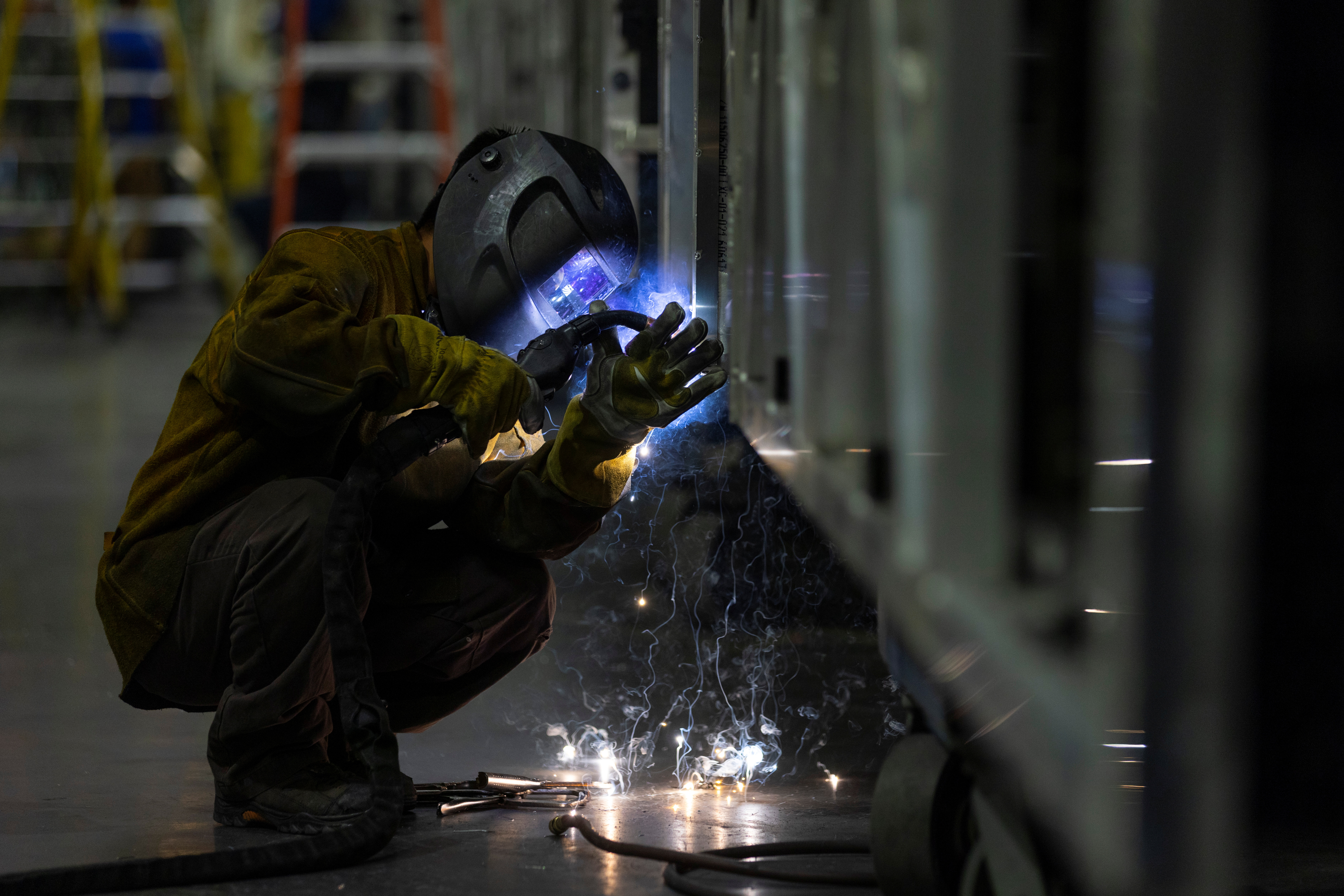 A welder works building a bus frame at the BYD electric bus factory in Lancaster, California