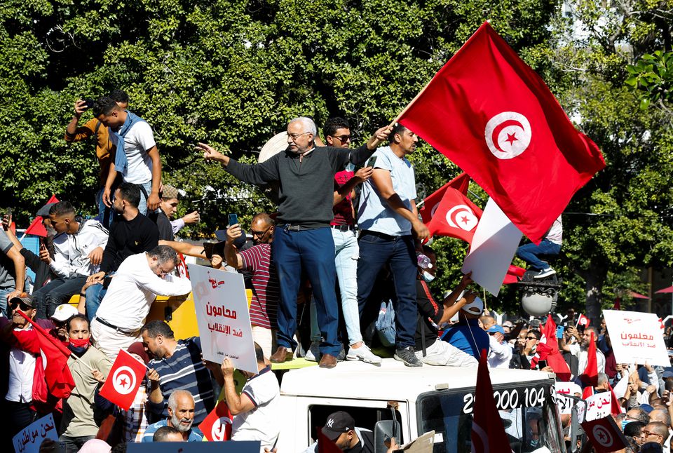 Demonstrators carry flags and banners during a protest against Tunisian President Kais Saied's seizure of governing powers, in Tunis