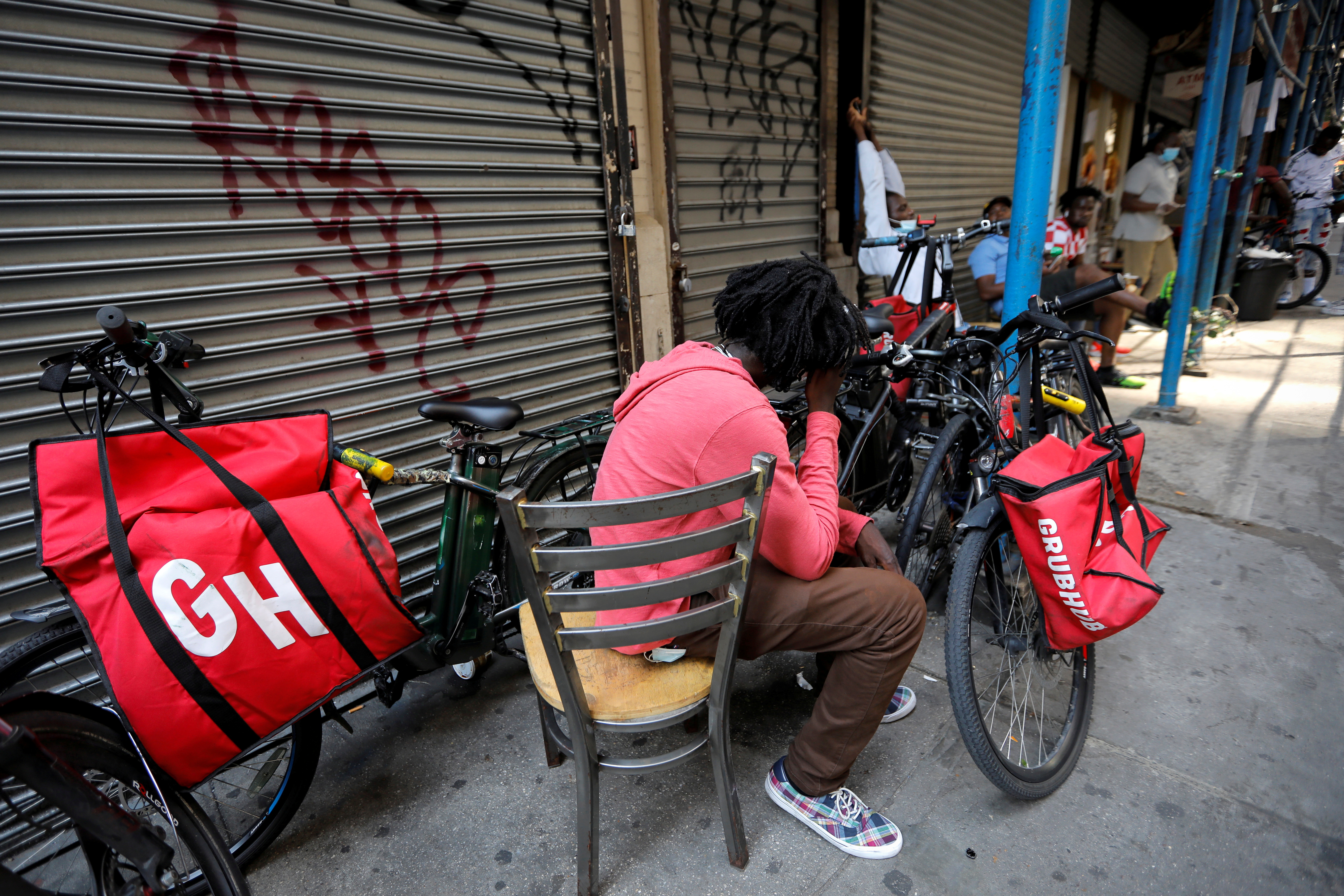 "Grubhub" delivery riders congregate between deliveries in midtown Manhattan in New York