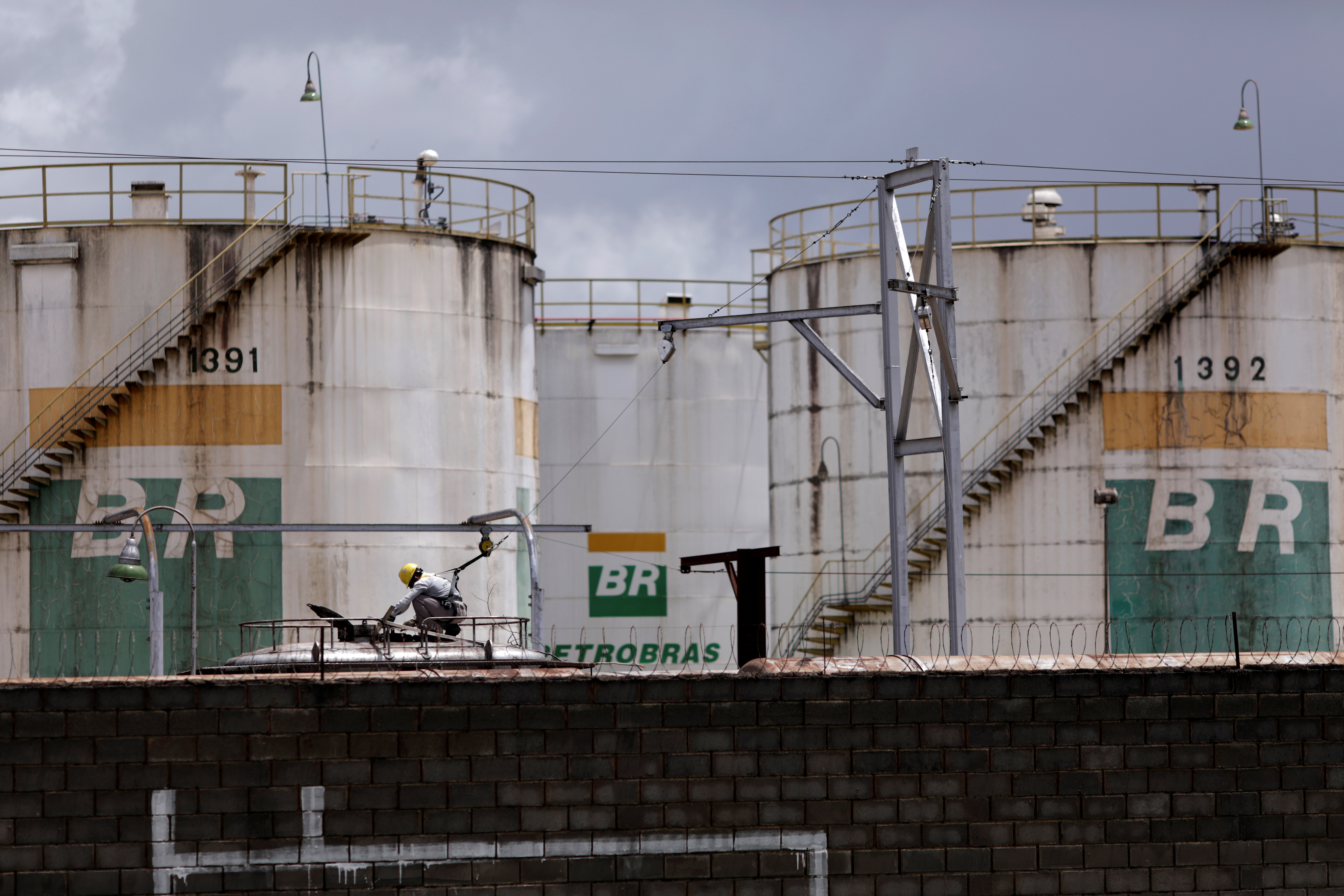 A worker checks the fuel volumes on a train wagon near a tank of Brazil's state-run Petrobras oil company in Brasilia, Brazil, February 19, 2021.