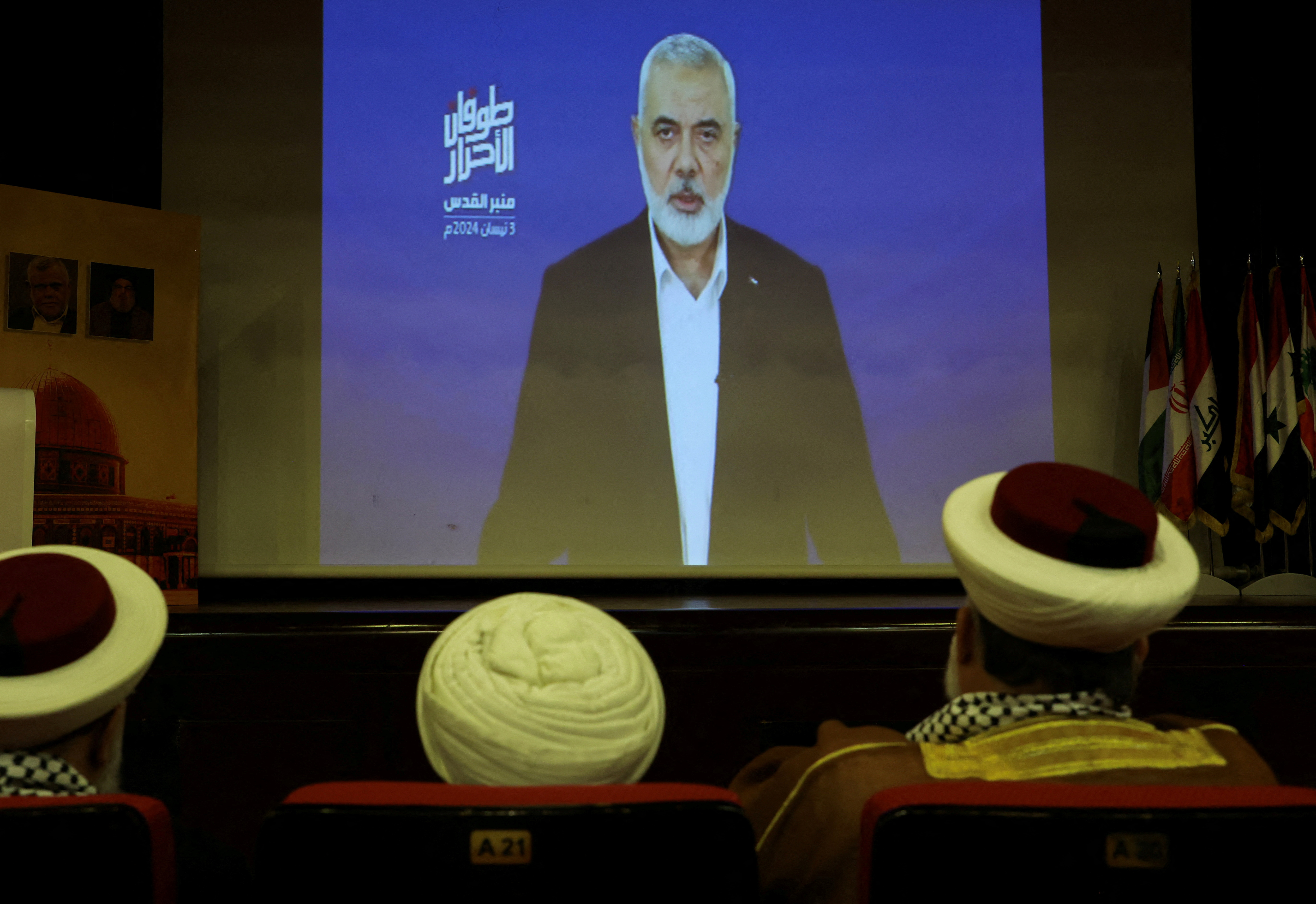 Hamas chief Ismail Haniyeh speaks in a pre-recorded message shown on a screen during an event ahead of al-Quds, in Beirut