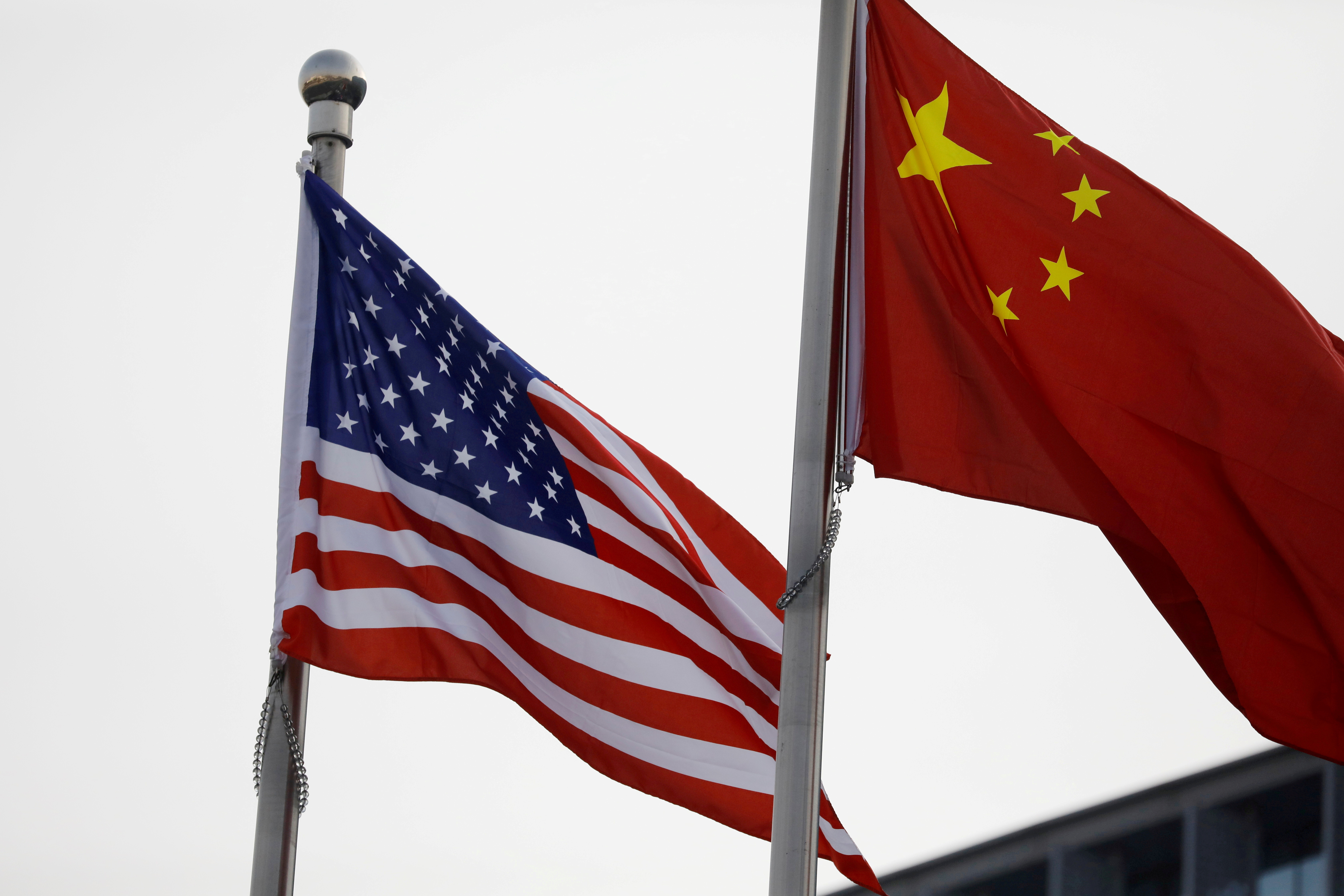 Chinese and U.S. flags flutter outside the building of an American company in Beijing, China January 21, 2021. REUTERS/Tingshu Wang