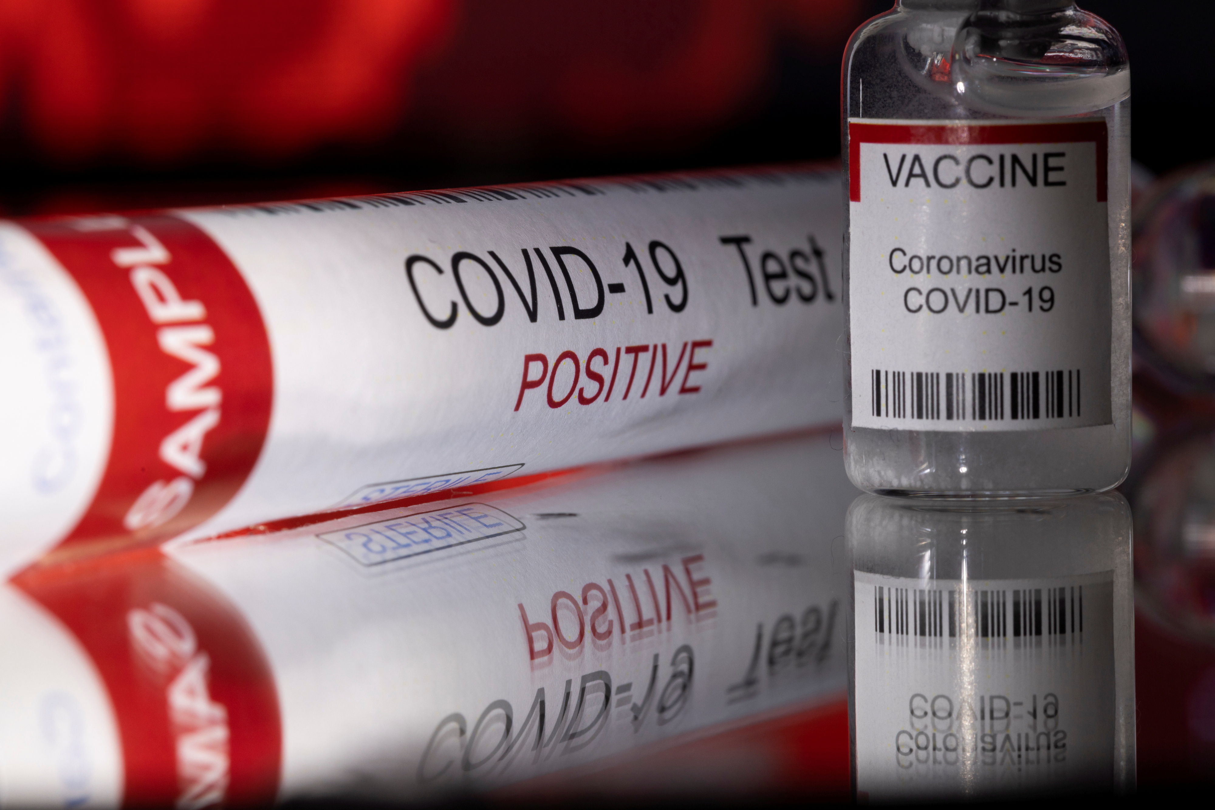 Illustration shows a test tube labelled "COVID-19 Test positive" and a vial labelled "VACCINE Coronavirus COVID-19\