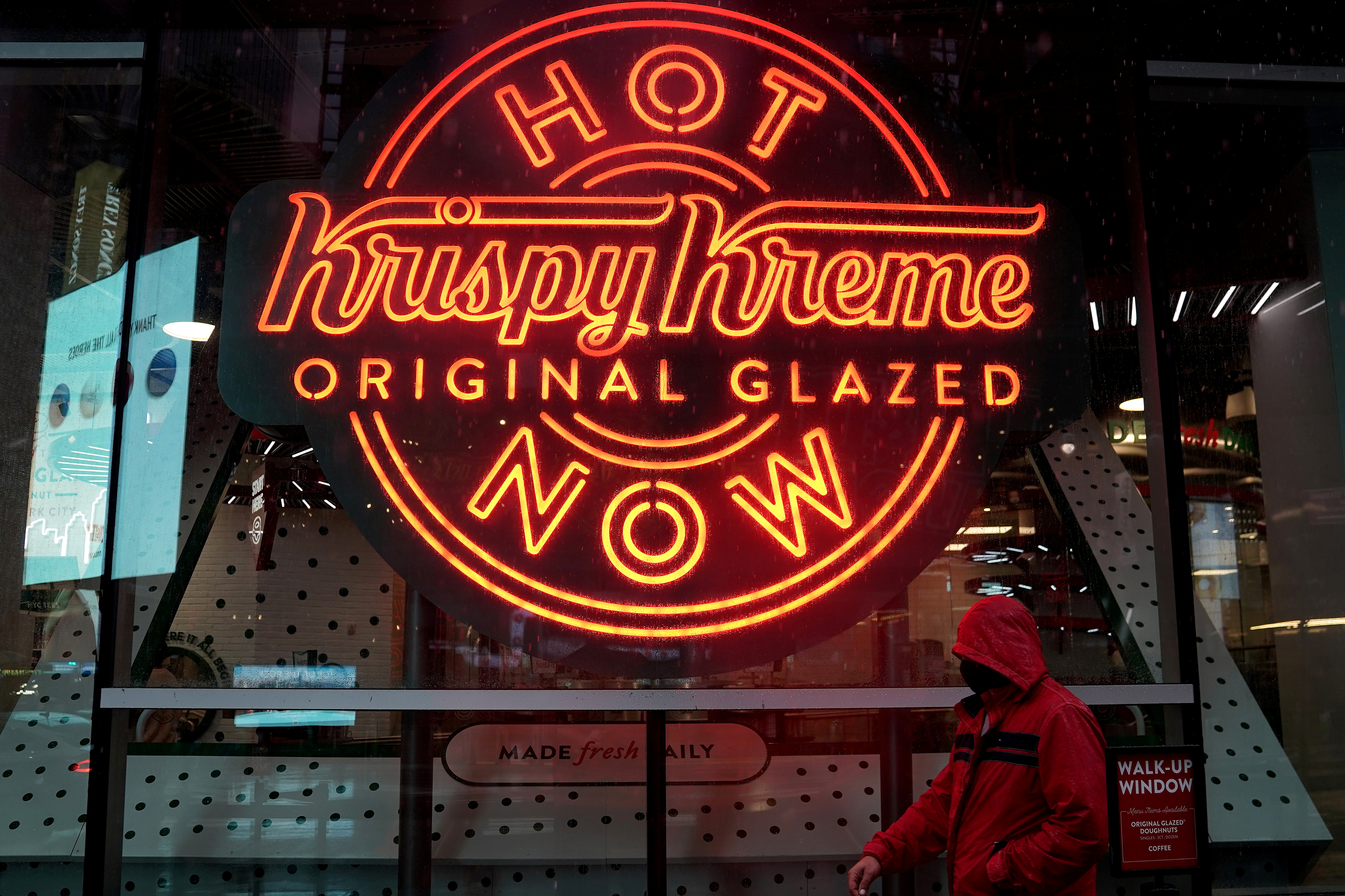 A man walks past a Krispy Kreme 