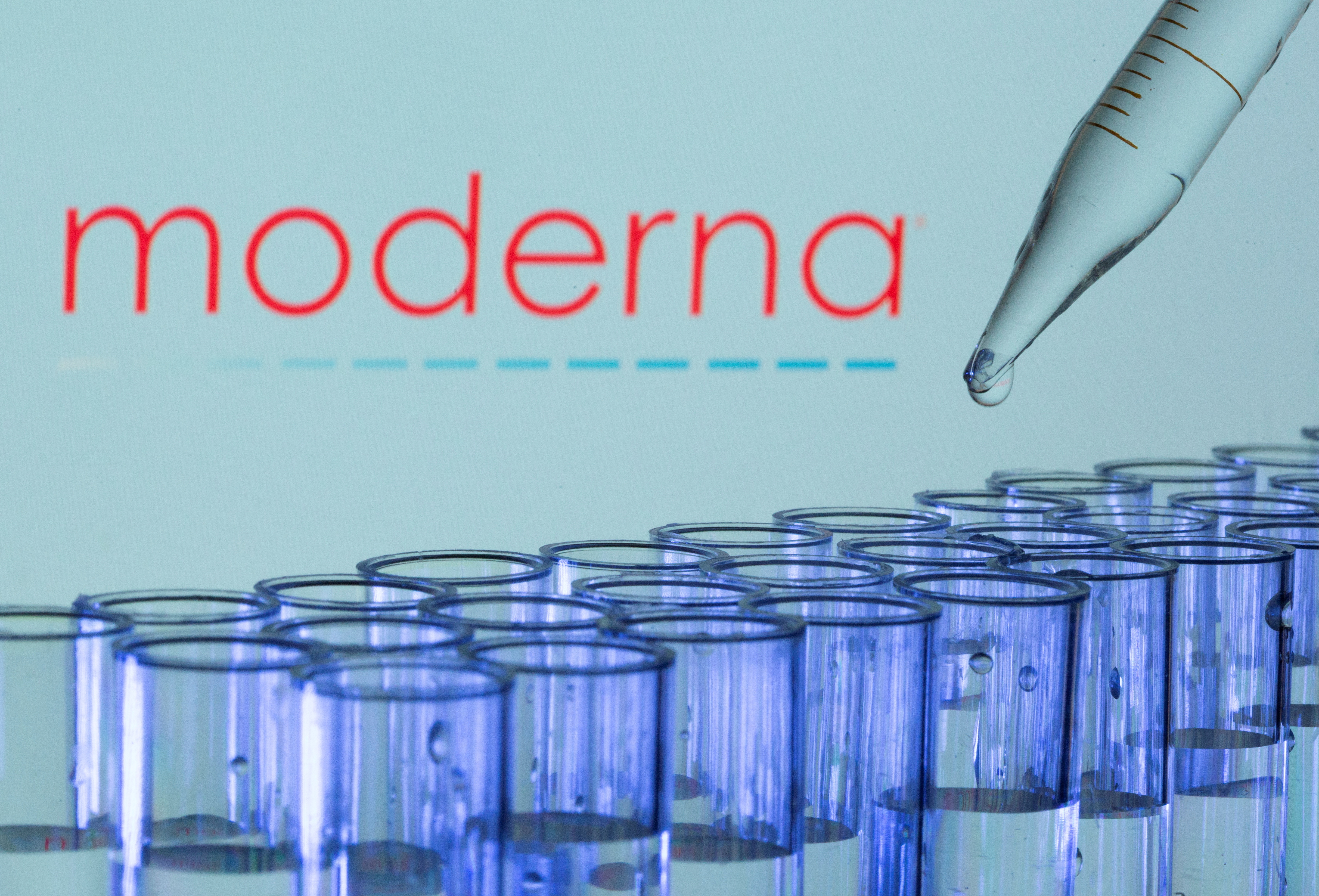 Test tubes are seen in front of a displayed Moderna logo in this illustration