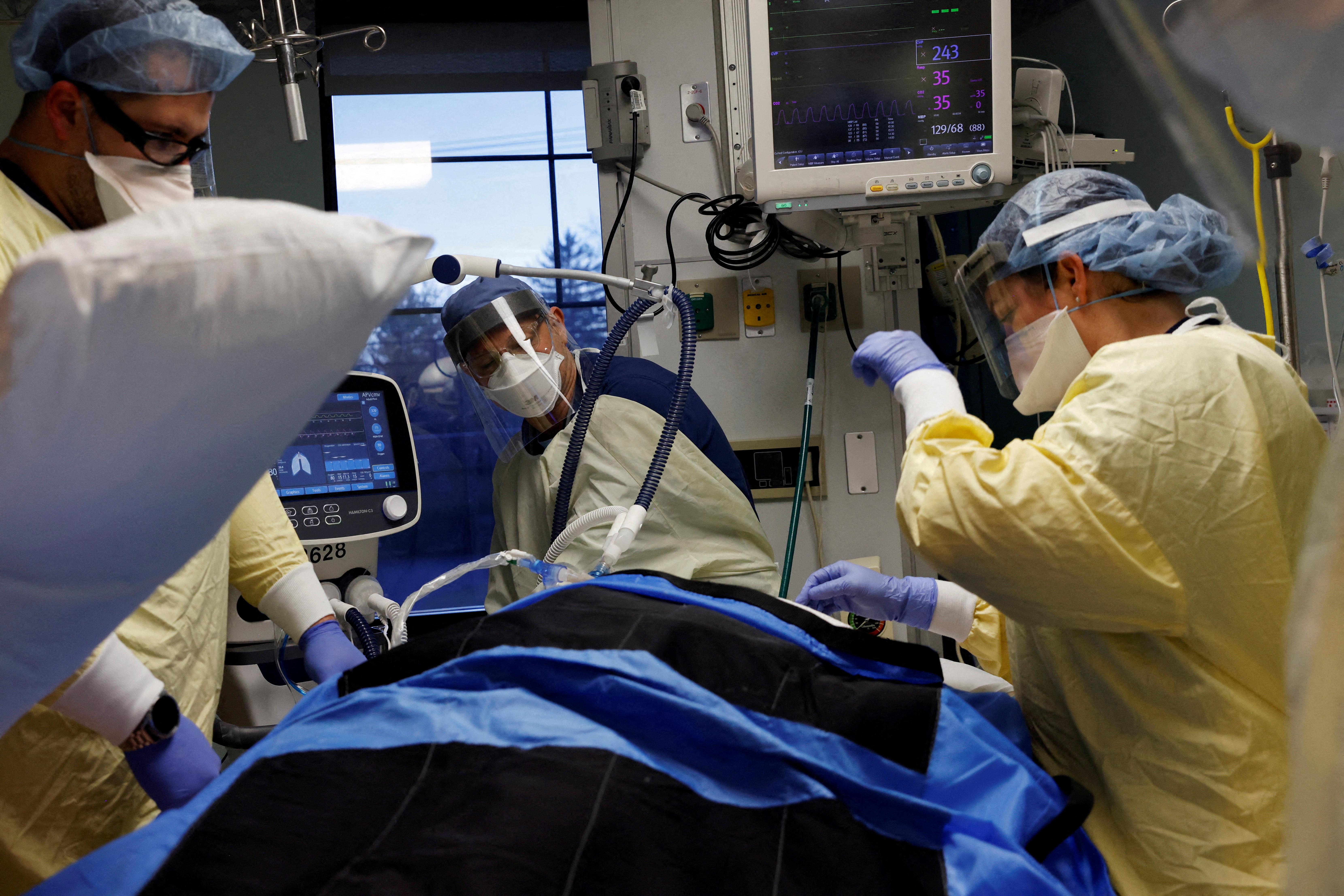 Medical staff treat a coronavirus disease (COVID-19) patient in their isolation room on the Intensive Care Unit (ICU) at Western Reserve Hospital in Cuyahoga Falls, Ohio, U.S., January 4, 2022. REUTERS/Shannon Stapleton