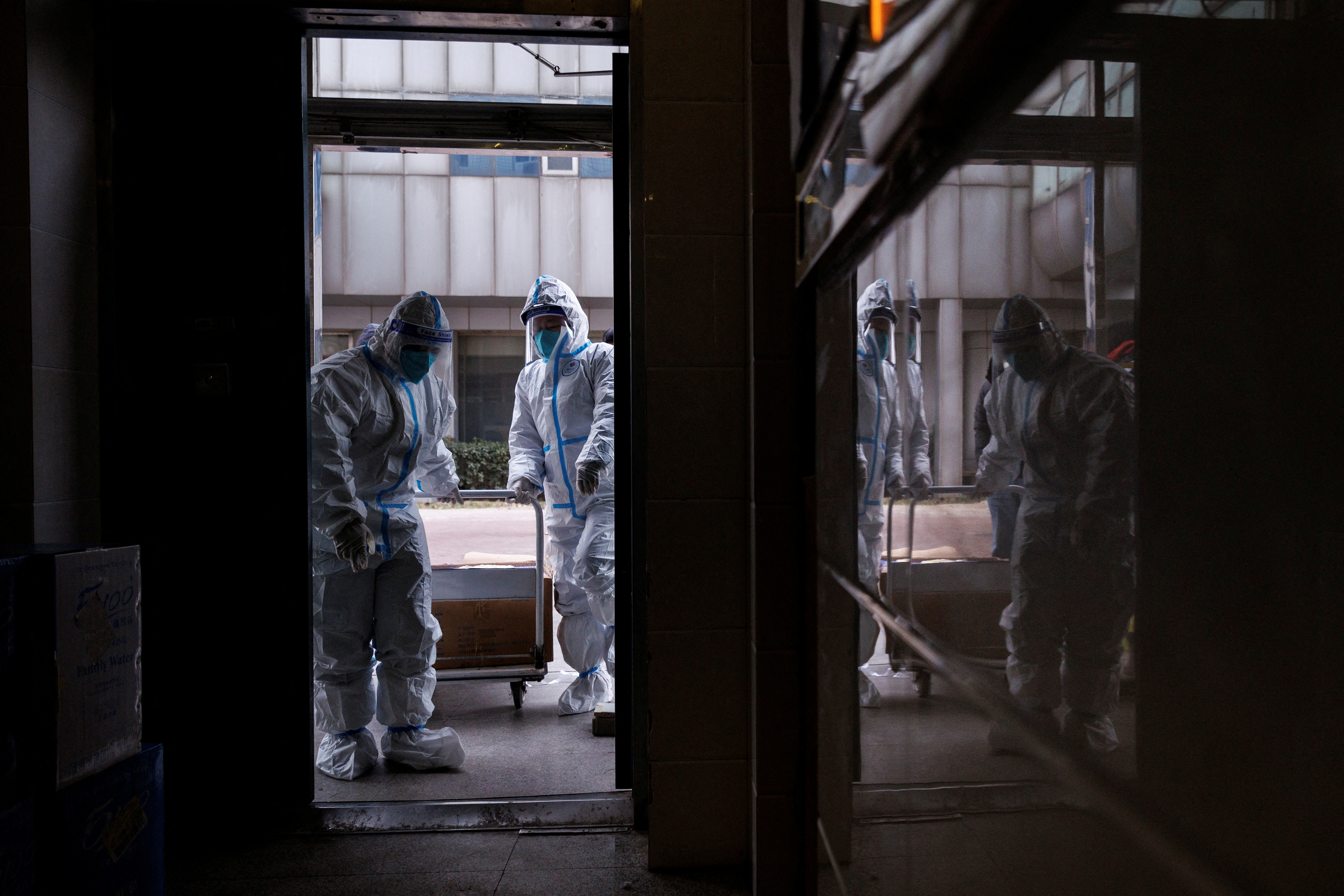 Pandemic prevention workers in protective suits enter an apartment building that went into lockdown as coronavirus disease (COVID-19) outbreaks continue in Beijing