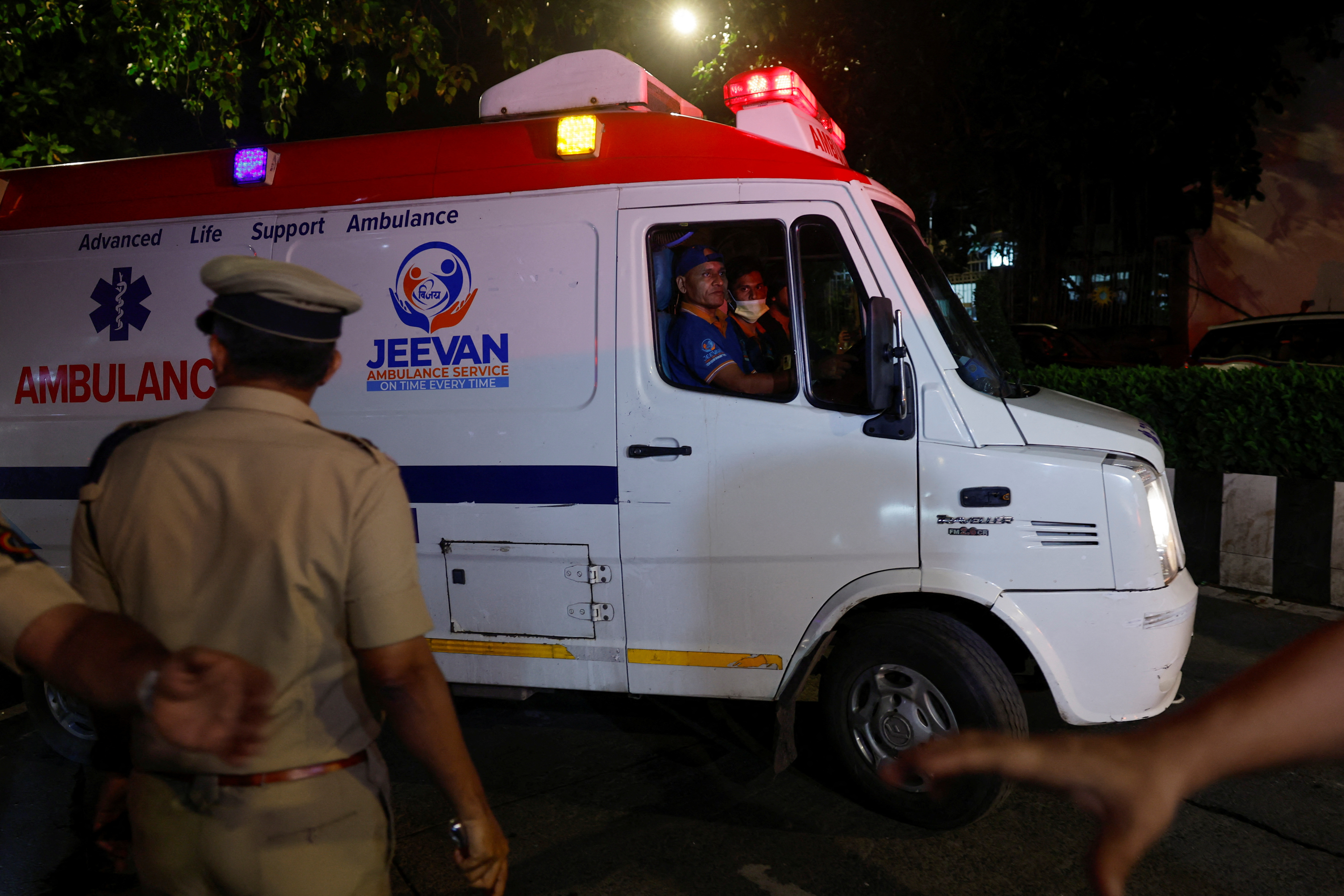 An ambulance drives with former chairman of Tata Group, Ratan Tata's body inside, as it leaves the hospital where he passed away, in Mumbai