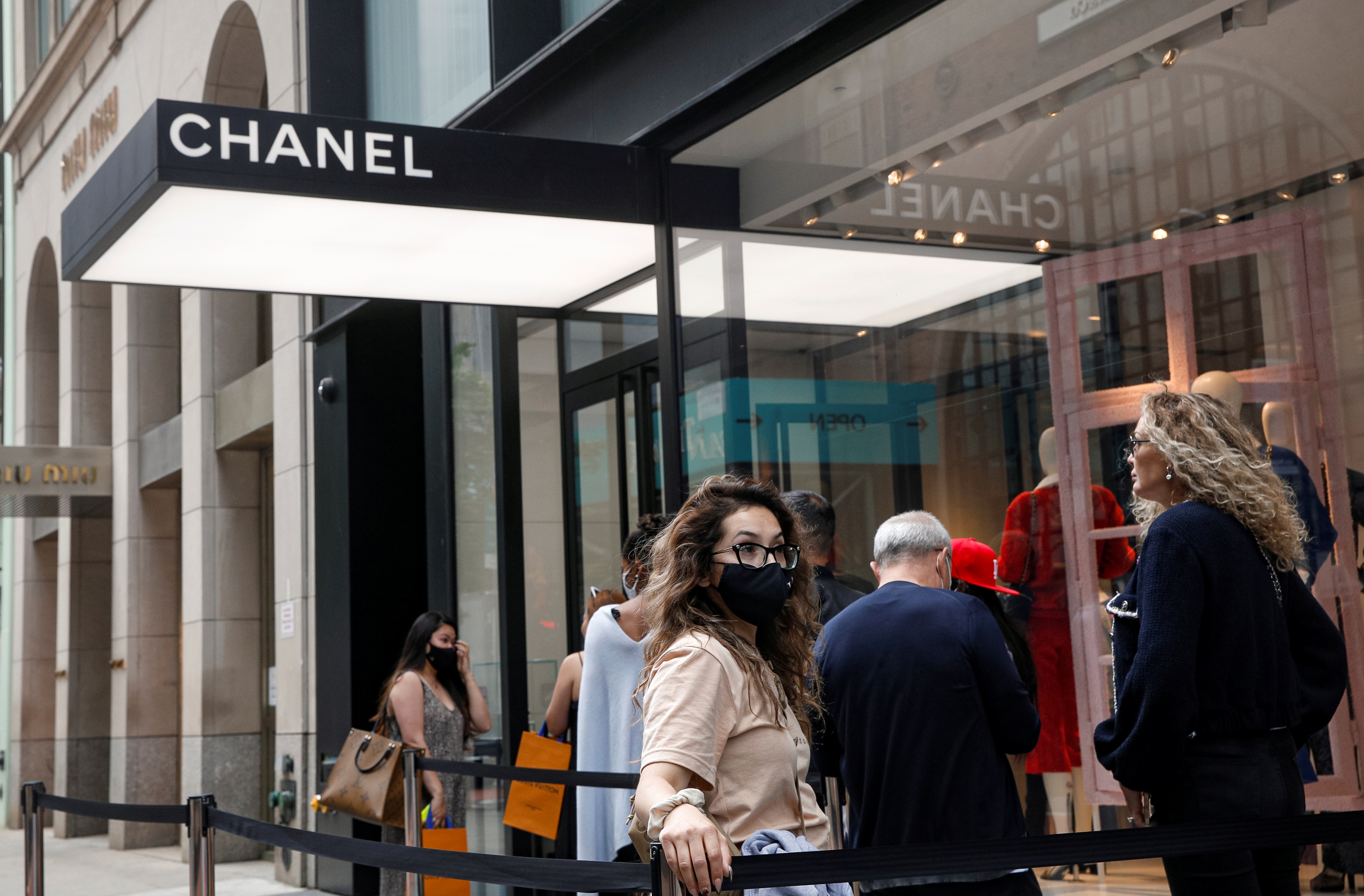 Shoppers wait in line to enter the Chanel store on 57th St in New York City, U.S., May 24, 2021.  REUTERS/Brendan McDermid