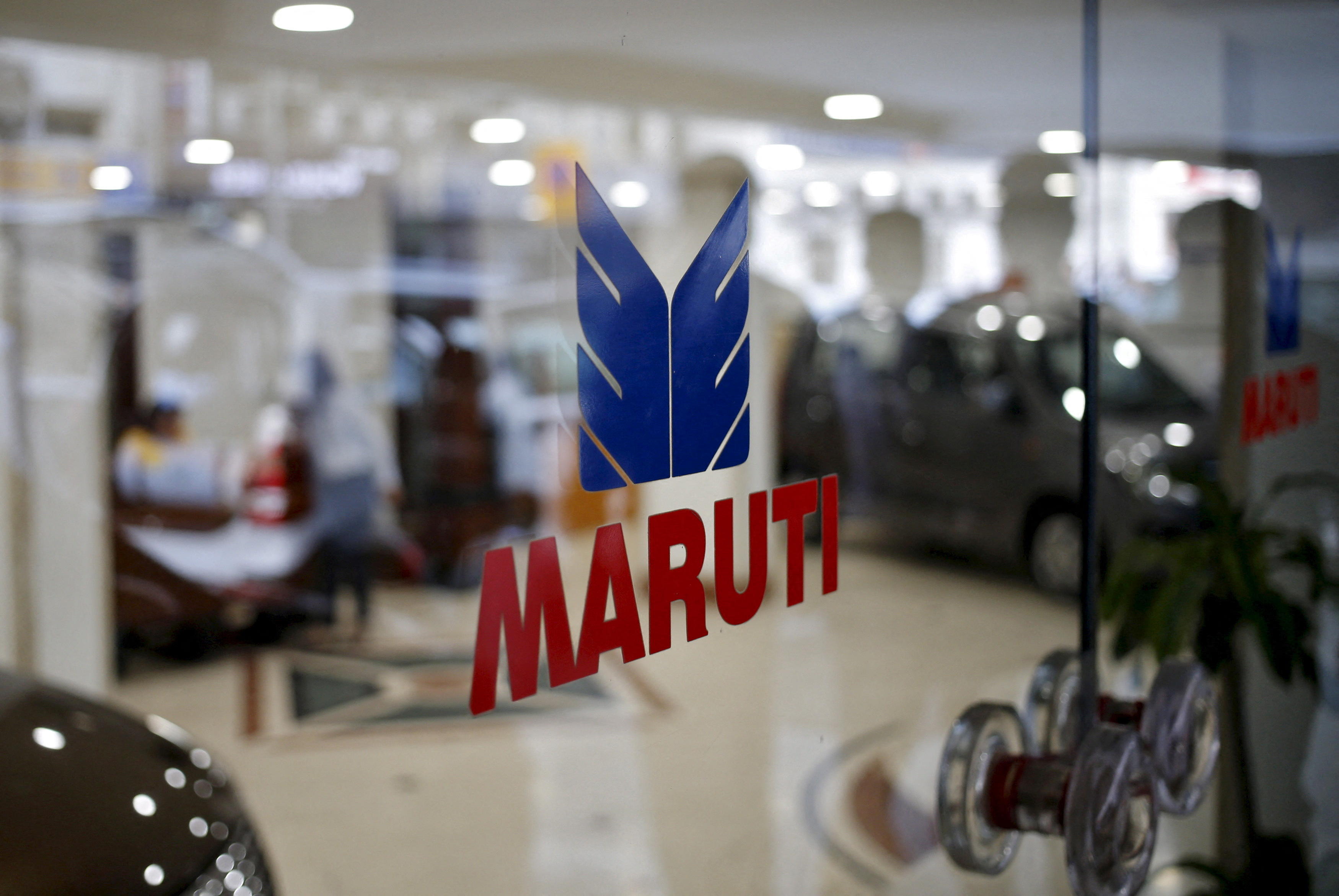 The logo of Maruti Suzuki India Limited is seen on a glass door at a showroom in New Delhi