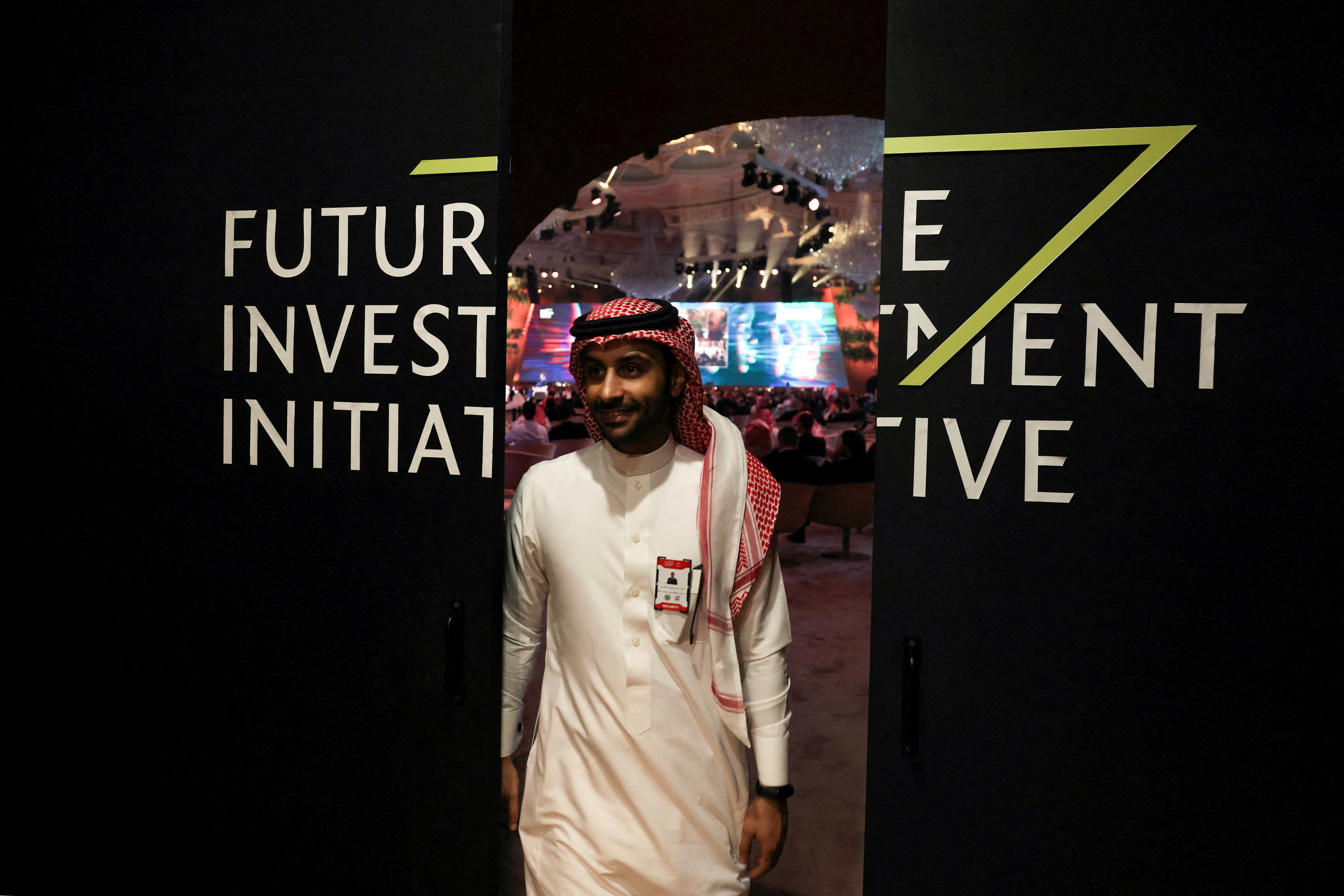 A Saudi man's reflection is seen in mirror glass at the Future Investment Initiative conference, in Riyadh, Saudi Arabia