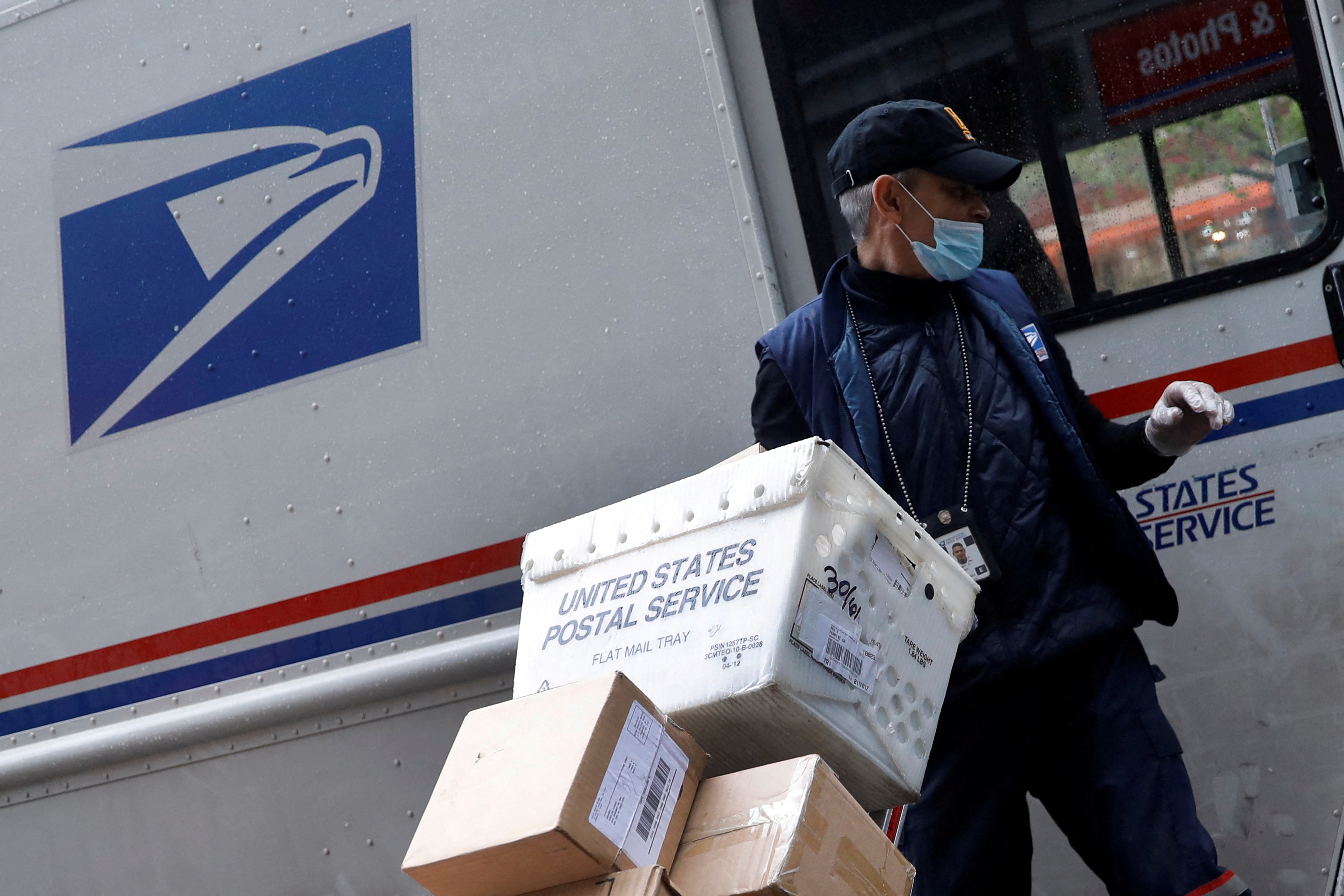 United States Postal Service (USPS) worker unloads packages in Manhattan during outbreak of coronavirus disease (COVID-19) in York