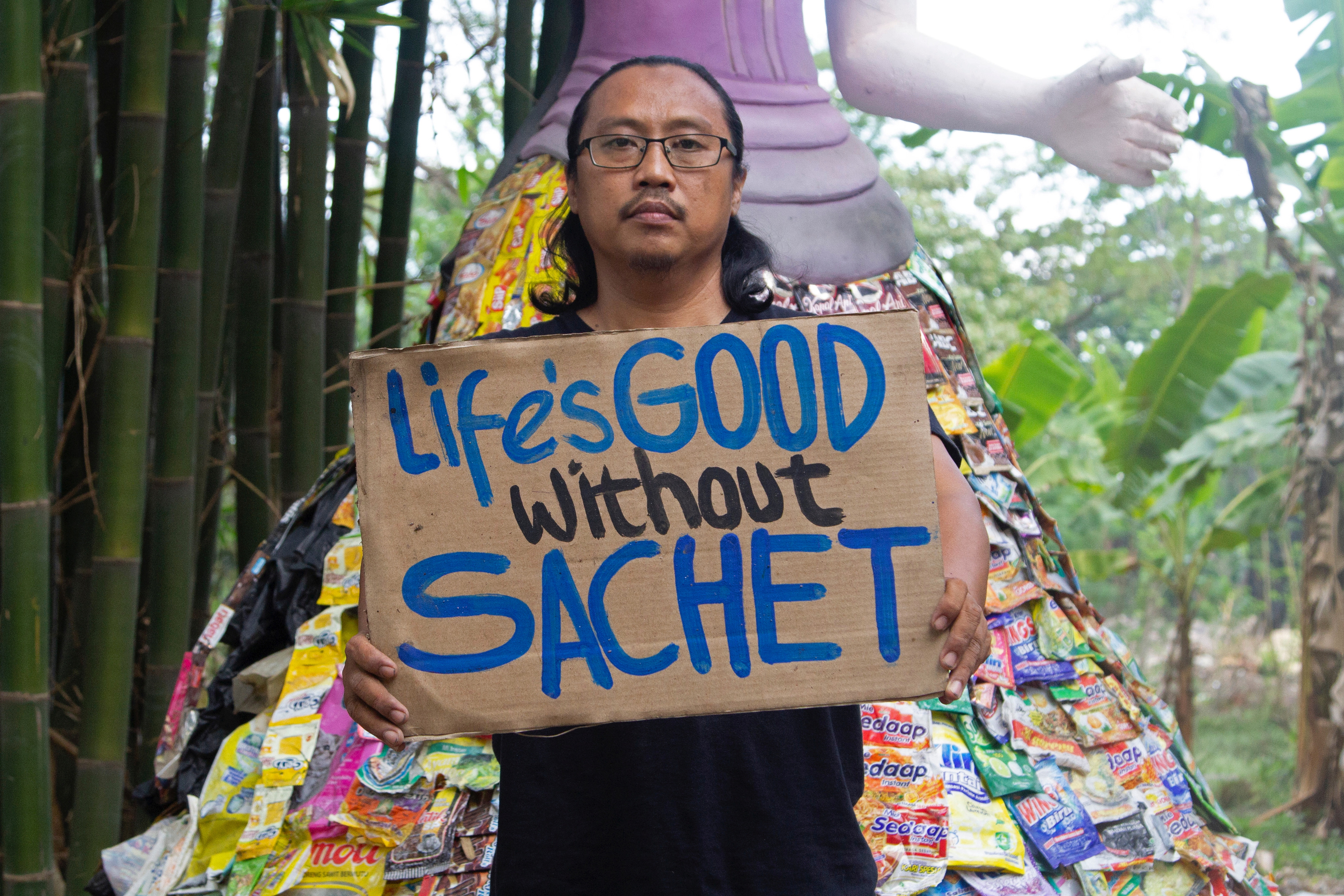 Prigi Arisandi, the founder of Indonesia's environmental activist group Ecological Observation and Wetlands Conservation (ECOTON), holds a placard as he poses for pictures in Gresik regency near Surabaya, East Java province, Indonesia, September 28, 2021. Picture taken September 28, 2021. REUTERS/Prasto Wardoyo