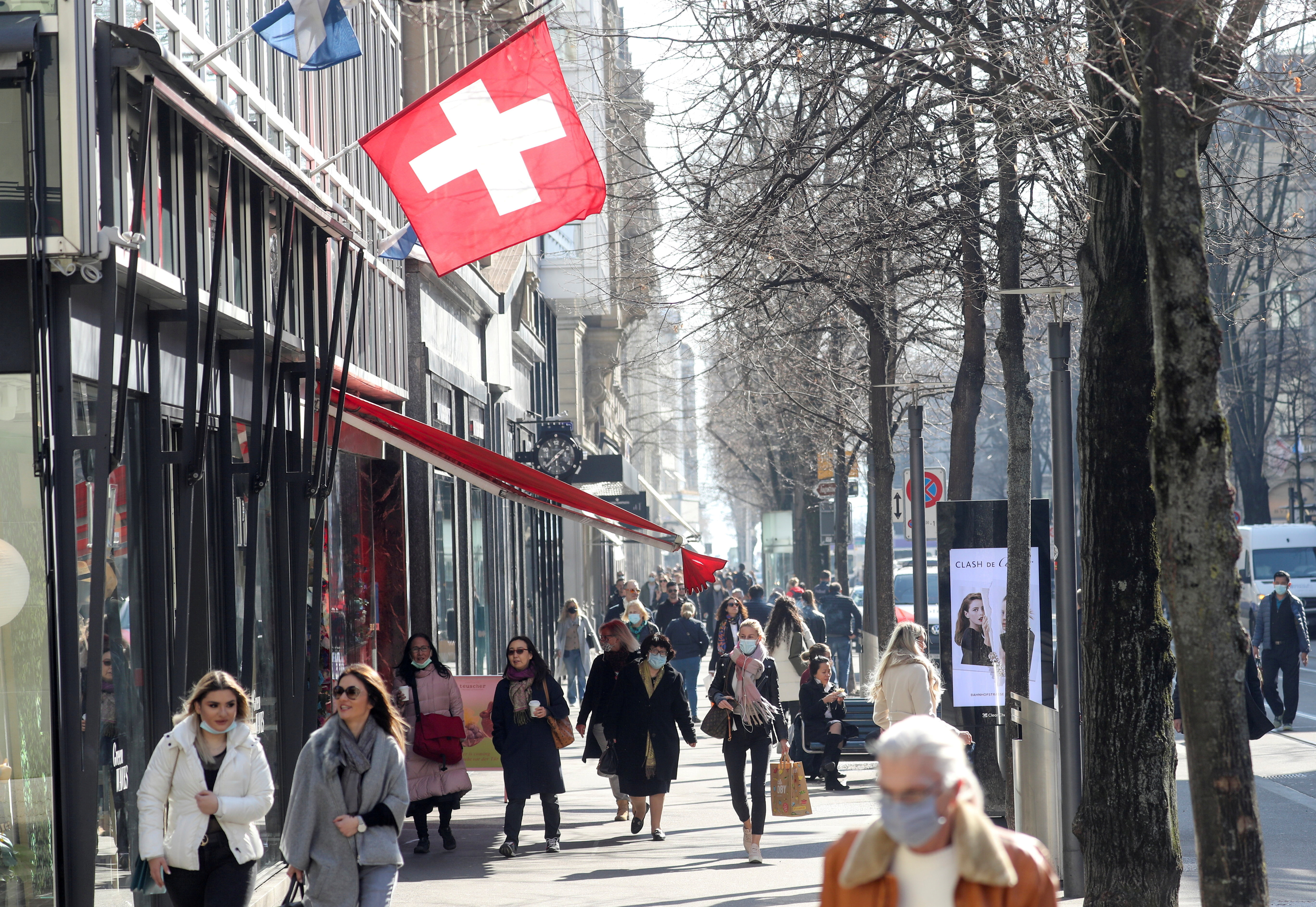 Shoppers walk along the street after the Swiss government relaxed some of its COVID-19 restrictions in Zurich