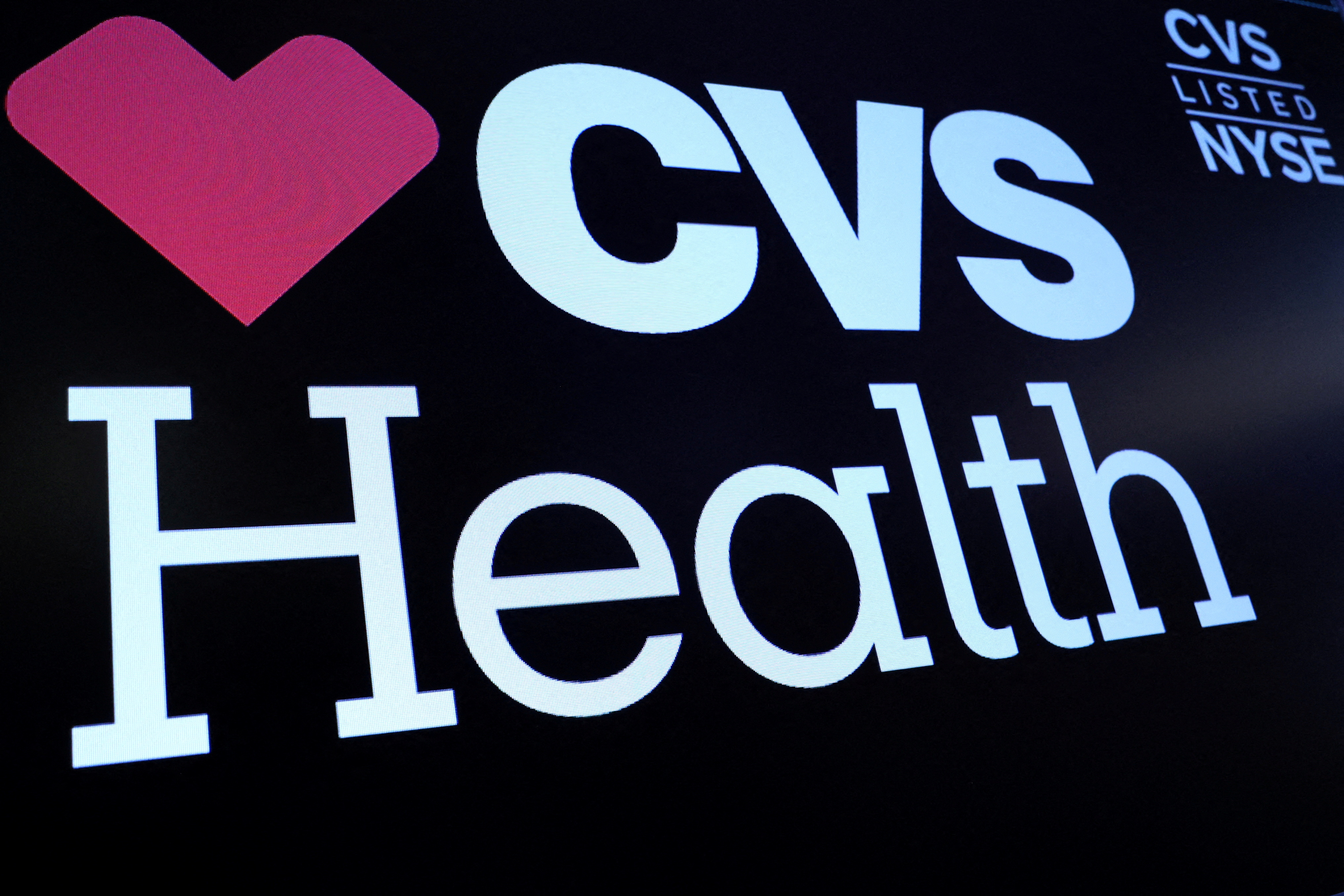 A screen displays the logo and trading information for CVS Health on the floor of the NYSE in New York