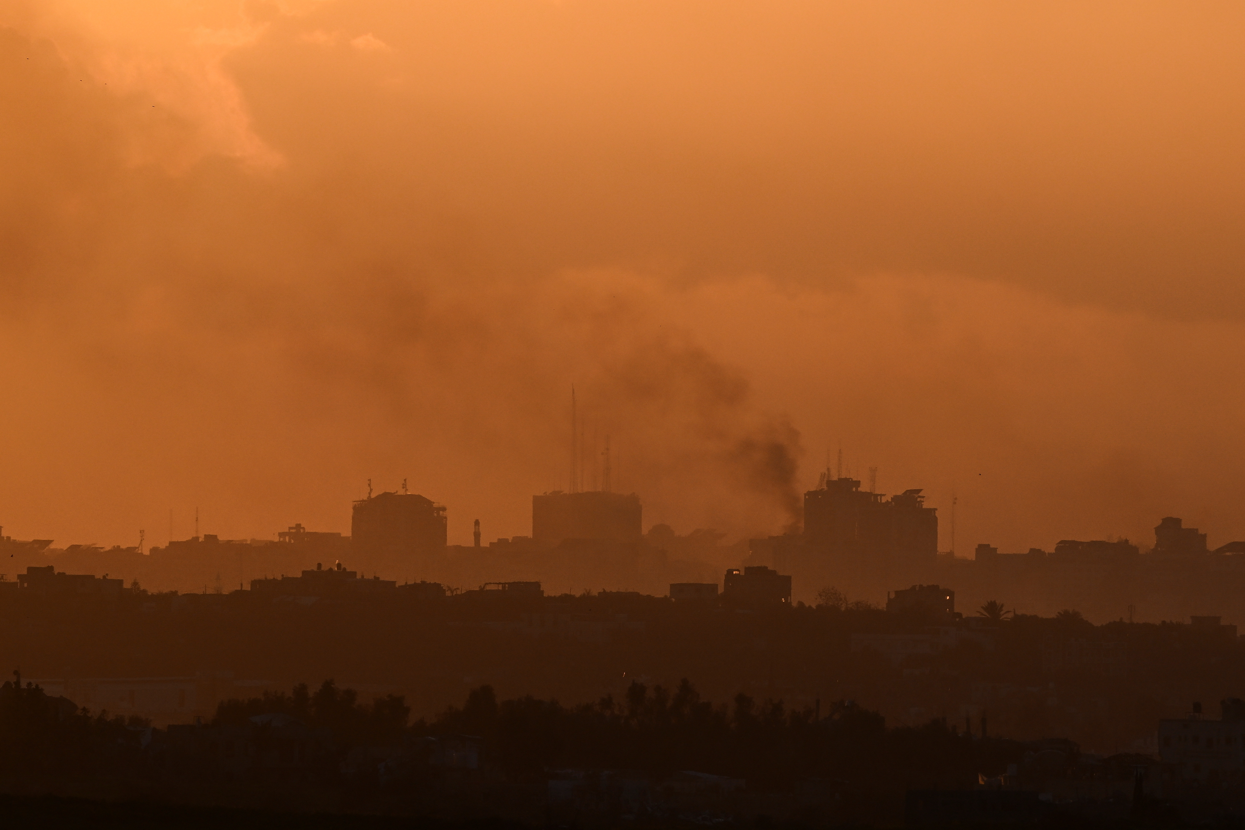 Smoke rises from Gaza, as the sun sets, amid the ongoing conflict between Israel and the Palestinian Islamist group Hamas, as seen from Sderot