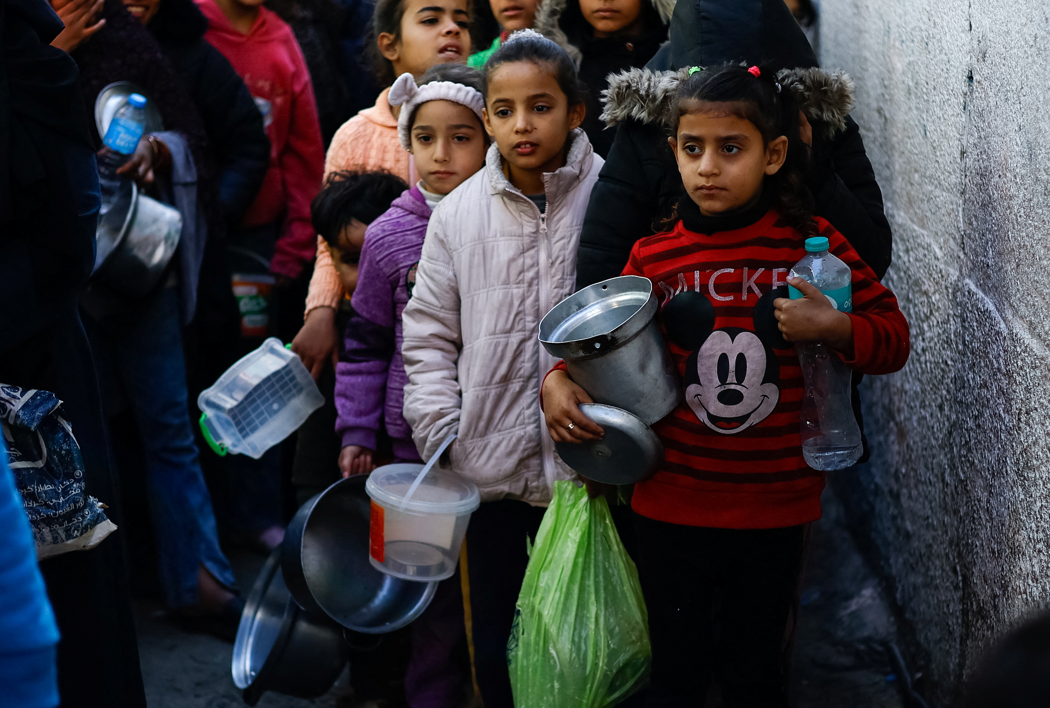 Palestinians wait to receive food amid shortages of food supplies, in Rafah in the southern Gaza Strip